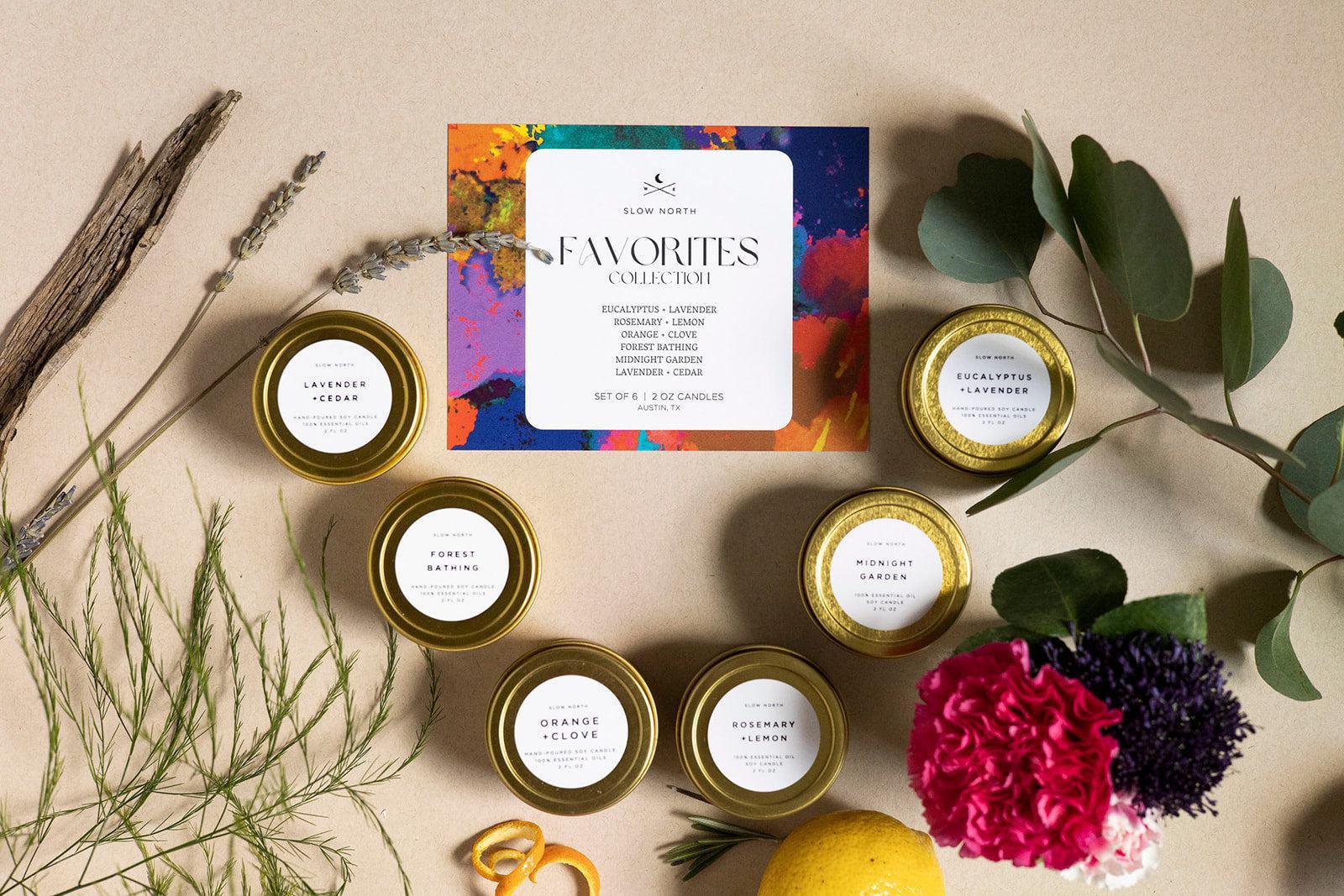 Set of six Slow North scented soy candles with eucalyptus, lavender, rosemary, and other natural fragrances displayed with fresh herbs and flowers
