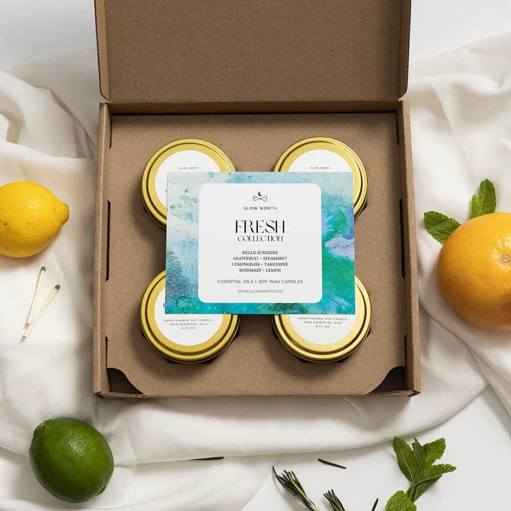 Slow North Fresh Collection soy wax candles gift box with essential oils surrounded by lemon, lime, and herbs