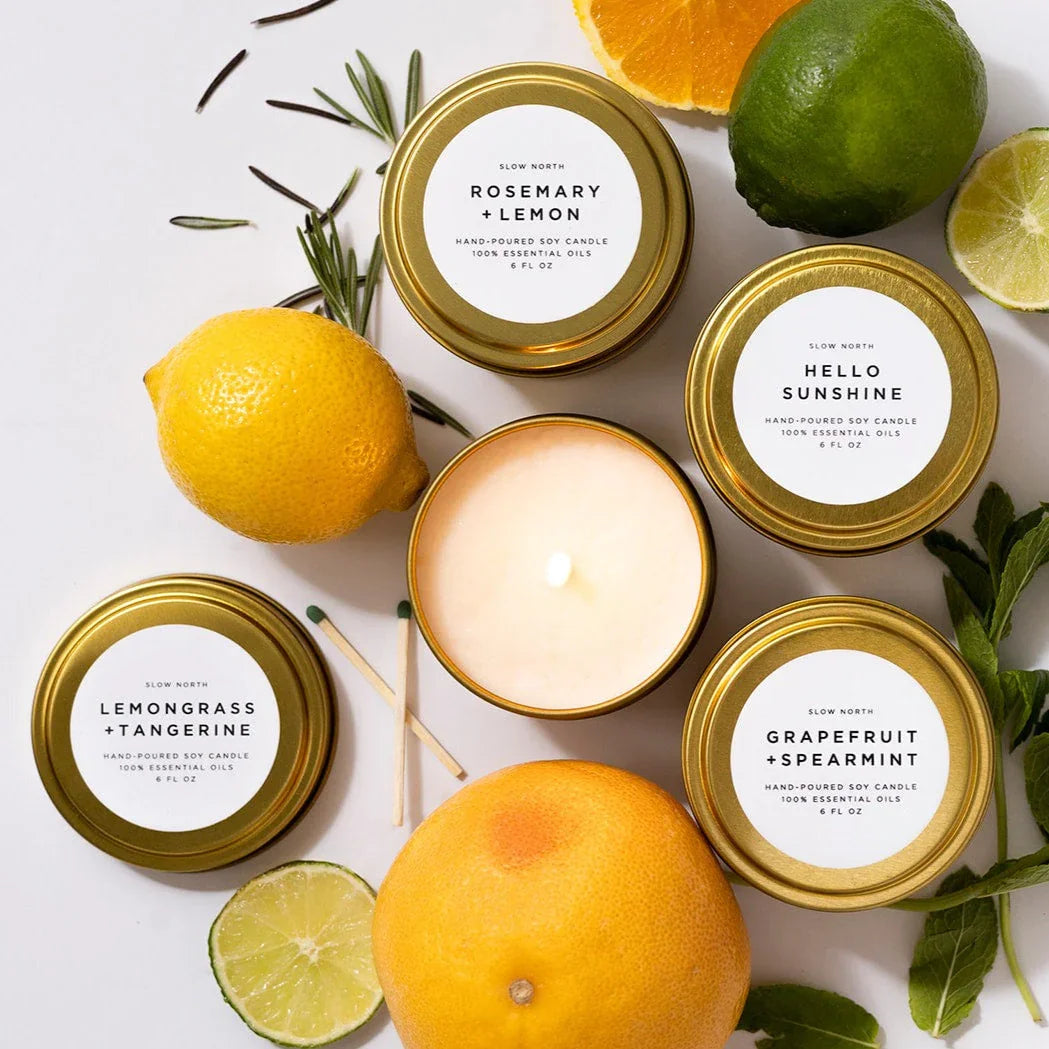 Hand-poured soy candles with lemon, lime, grapefruit, rosemary, and mint on white surface