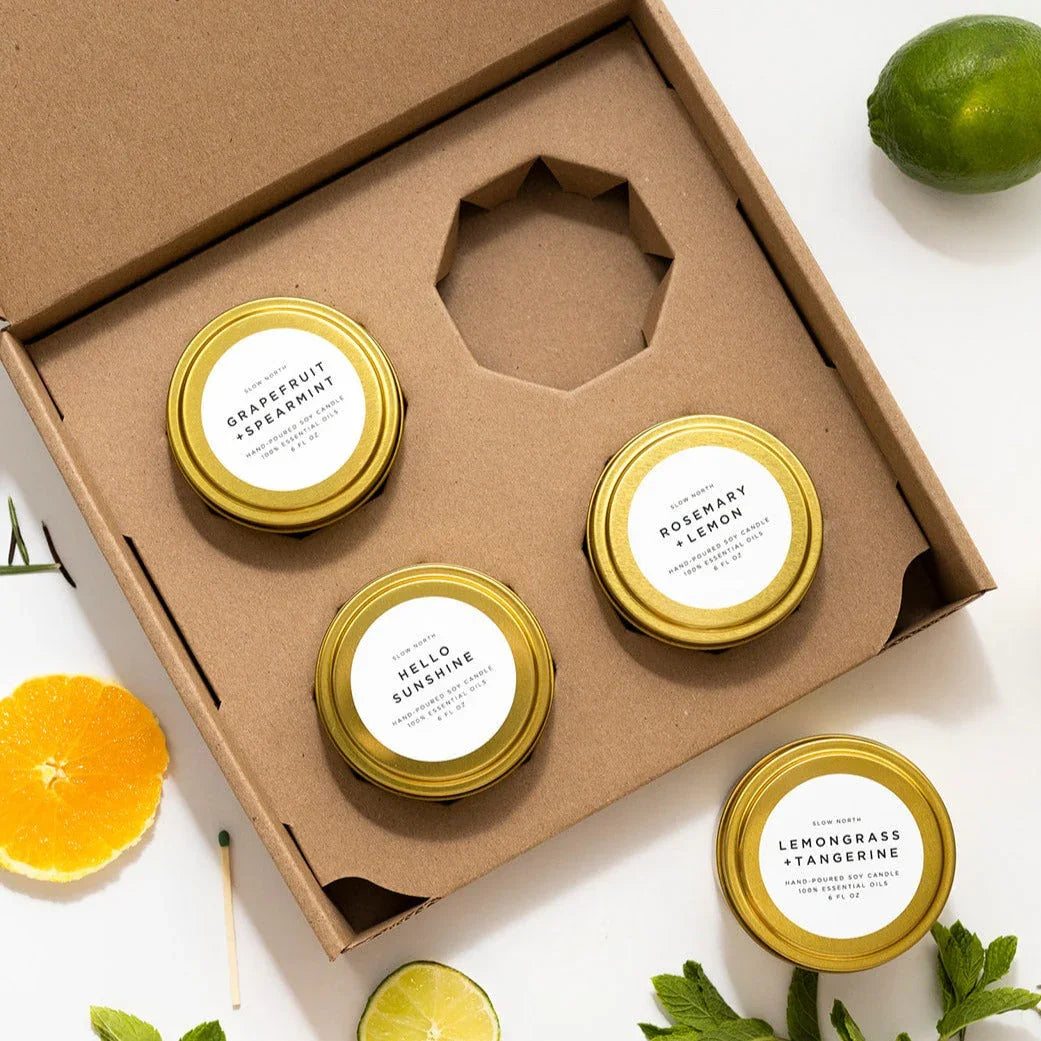 Set of four scented soy candles in gold tins with grapefruit, spearmint, rosemary, lemon, lemongrass, and tangerine scents