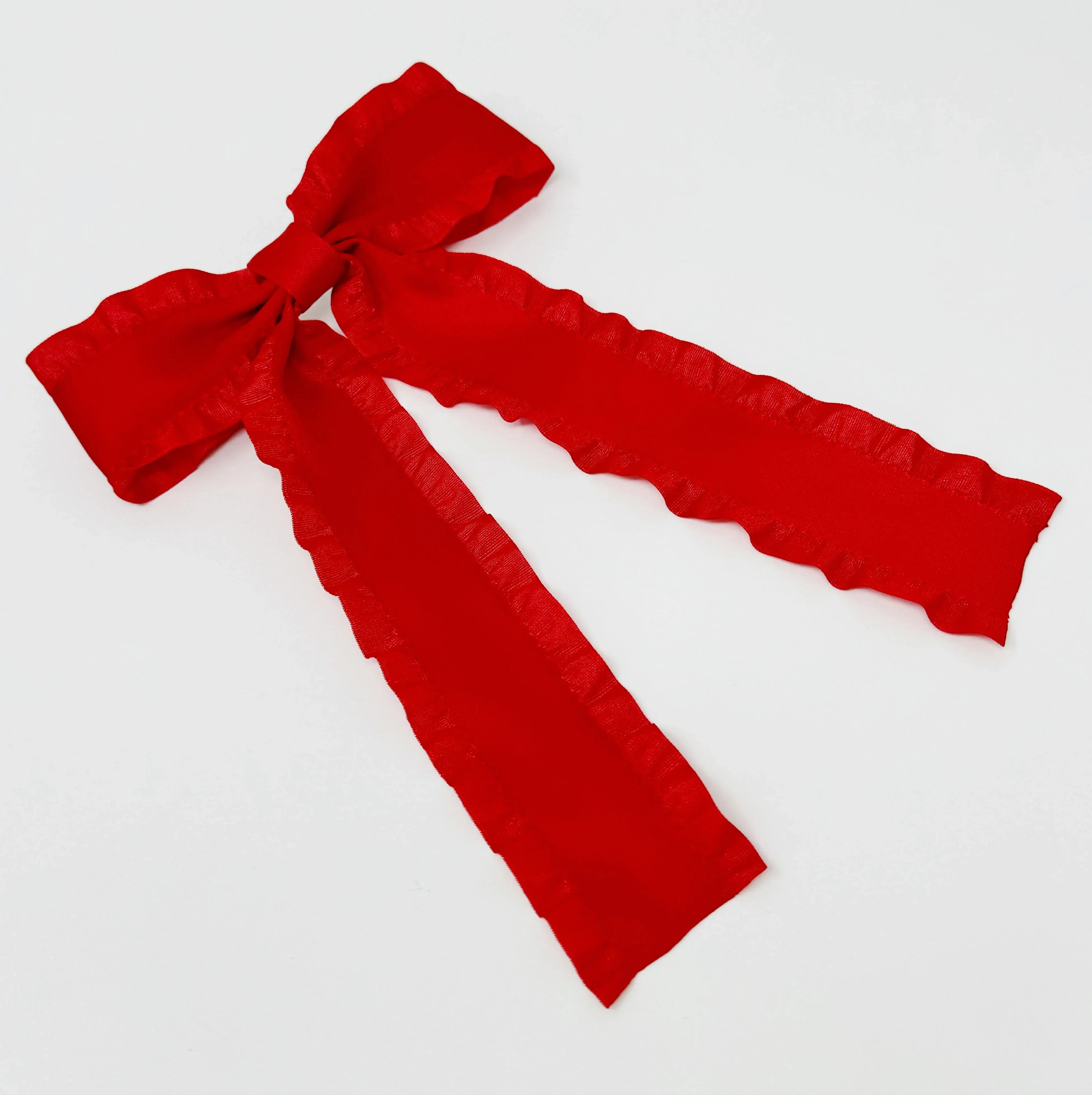 Bright red fabric bow with ruffled edges on a white background