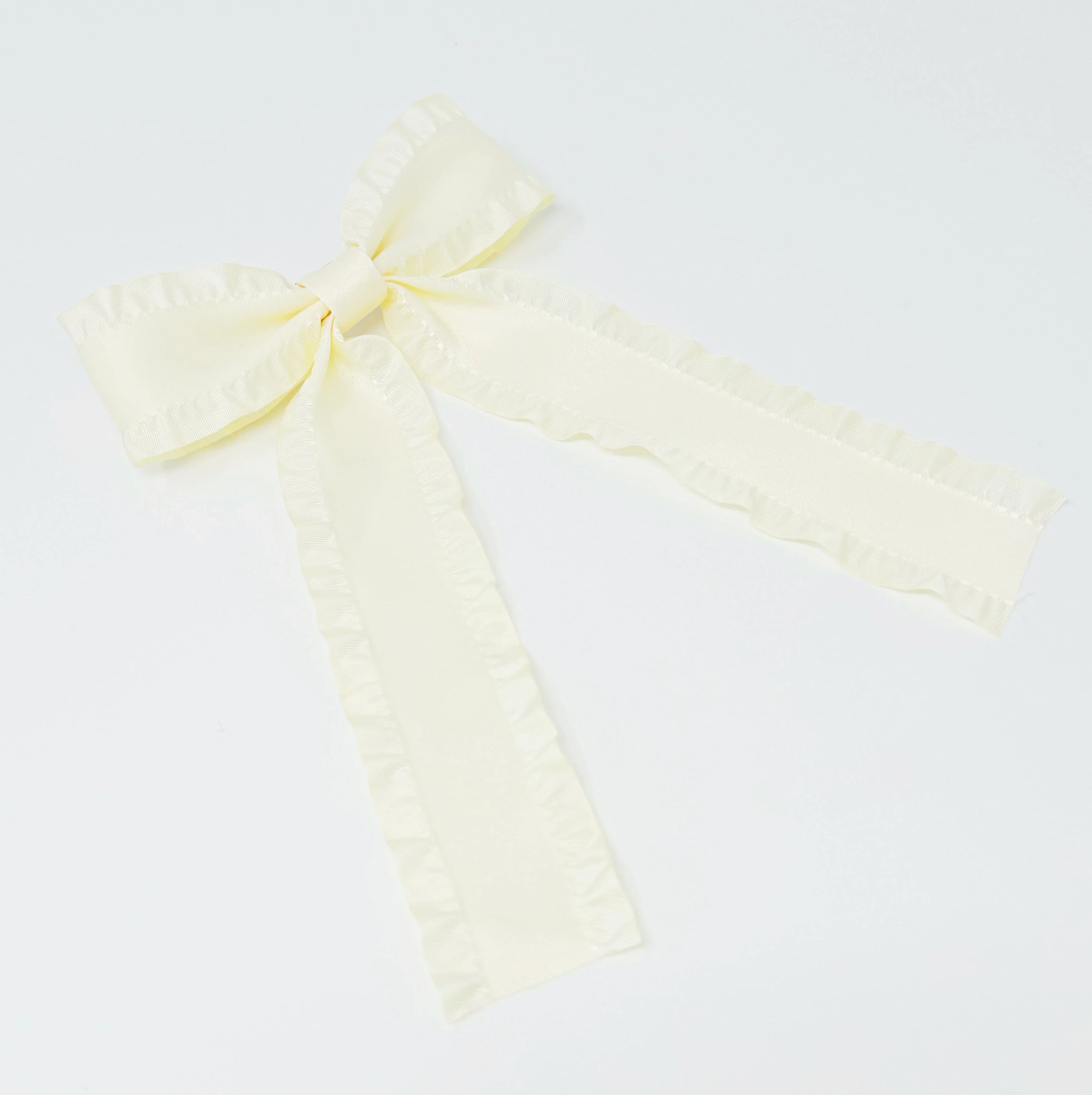 Cream satin ribbon bow with ruffled edges on white background