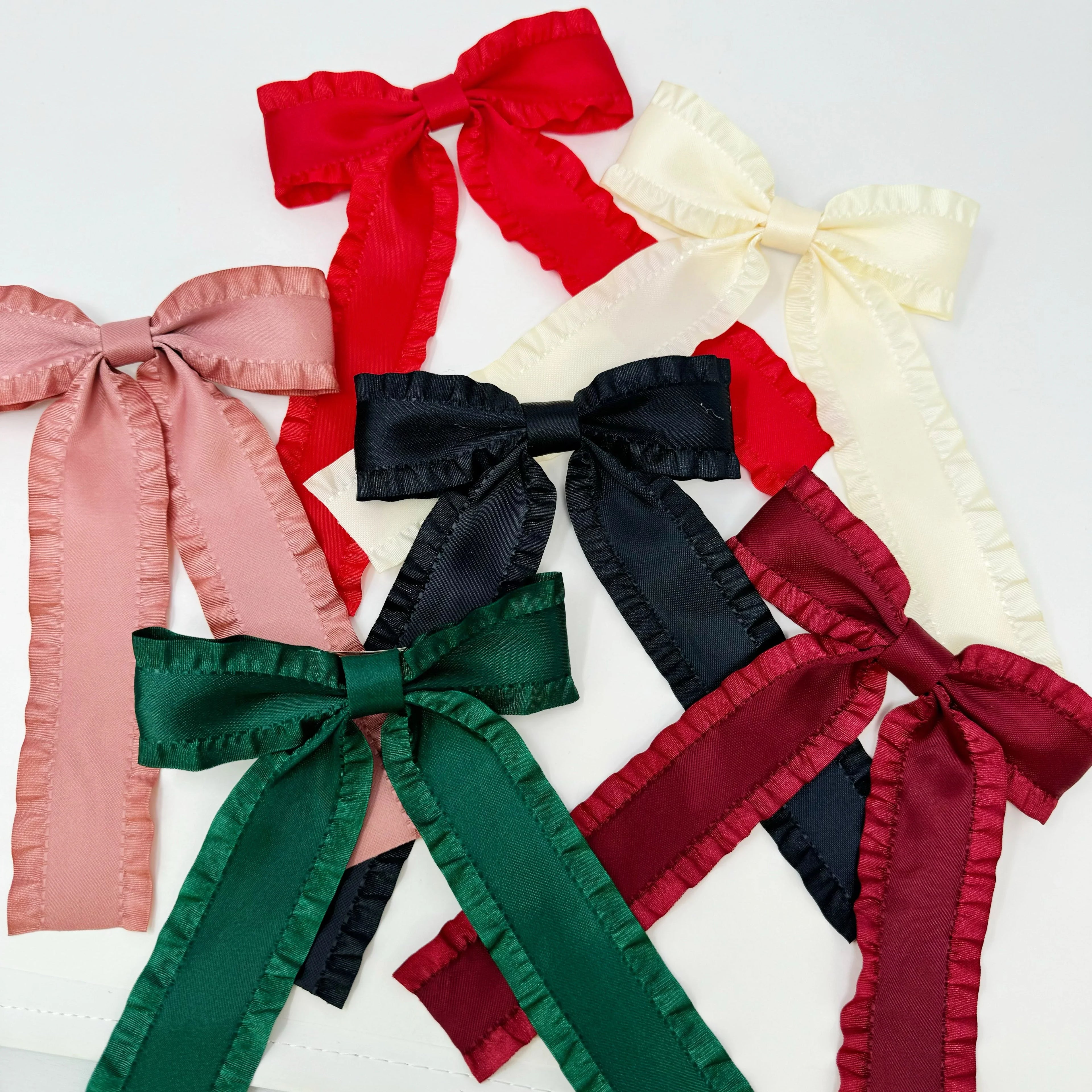 Collection of satin ruffle-edge hair bows in red, cream, pink, black, green, and burgundy colors