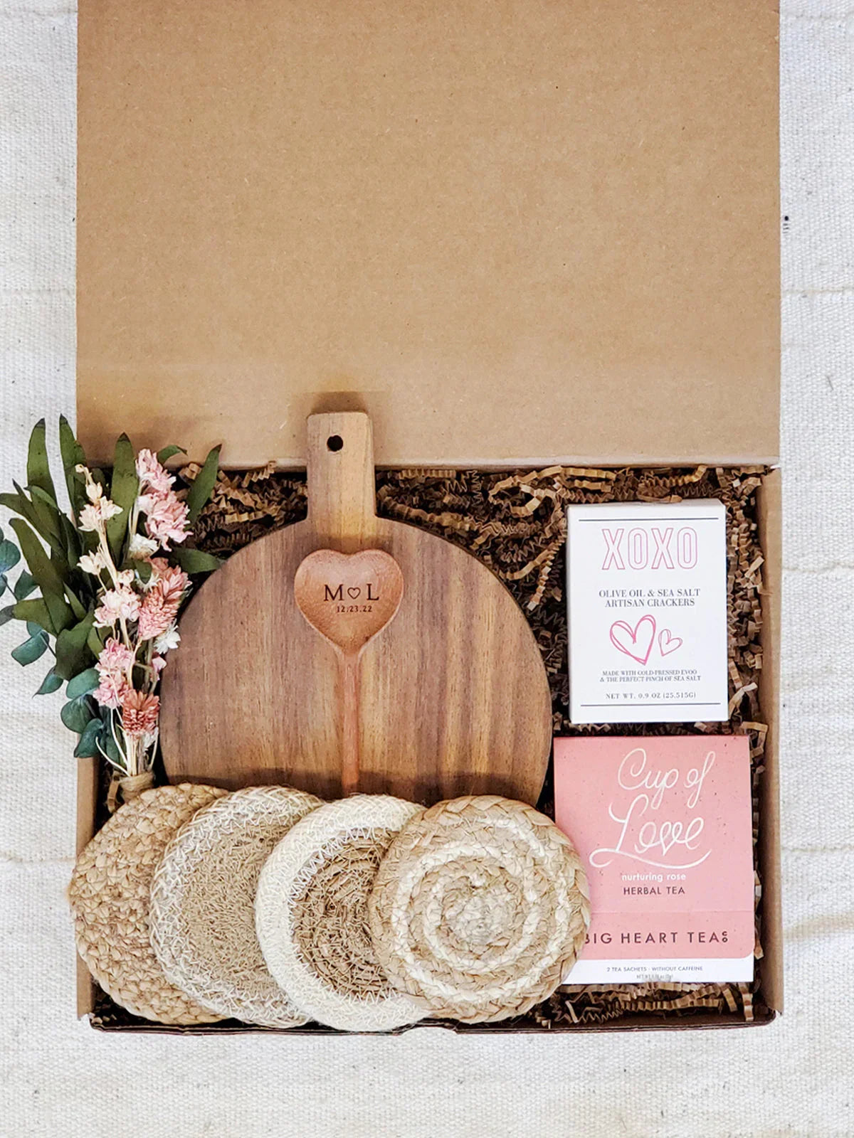 Gift box with personalized wood cutting board monogram M♡L, floral bouquet, coasters, herbal tea, and artisan crackers