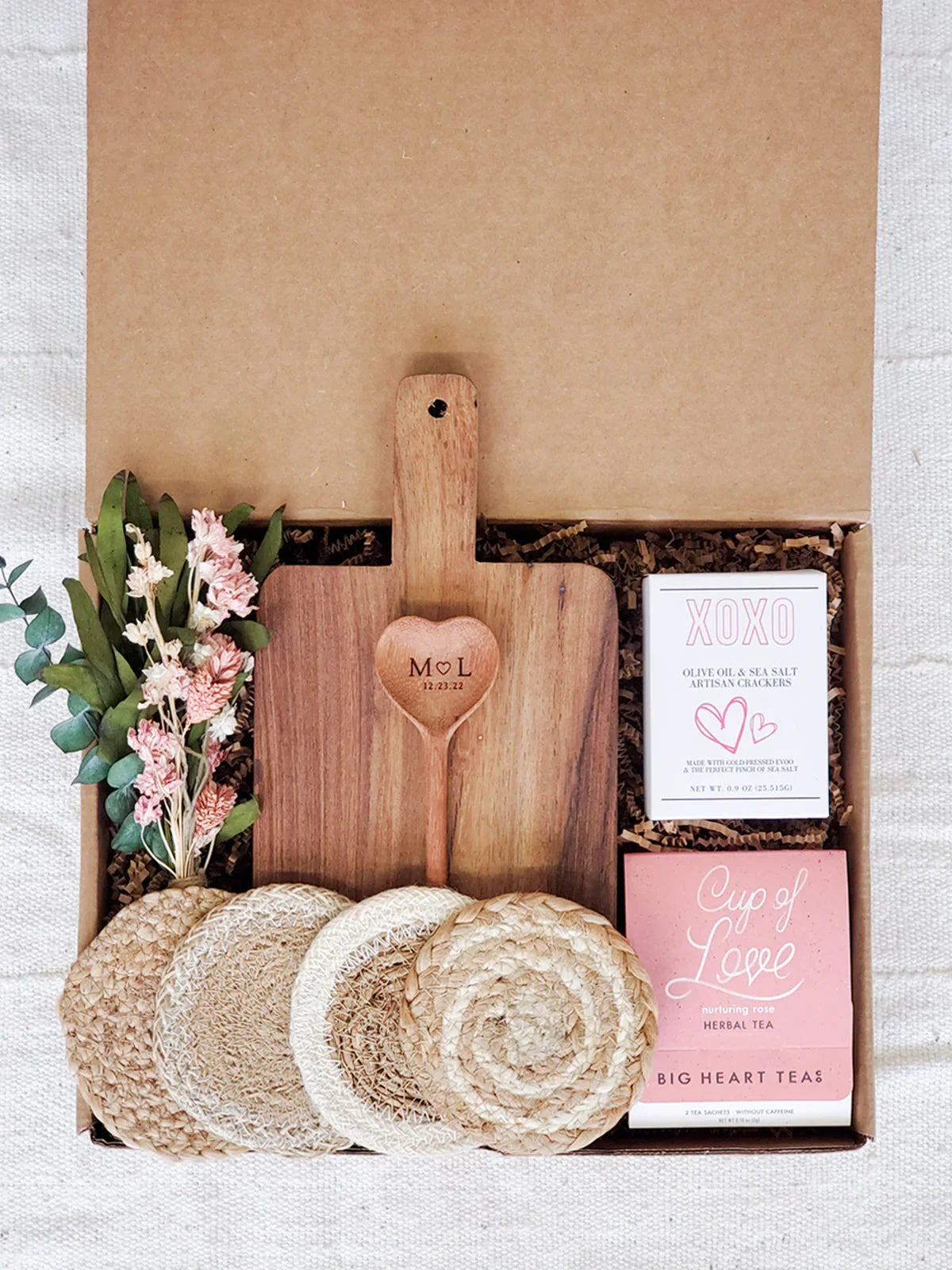 Gift box with wooden monogrammed cutting board and heart spoon, artisan crackers, herbal tea, and dried flowers
