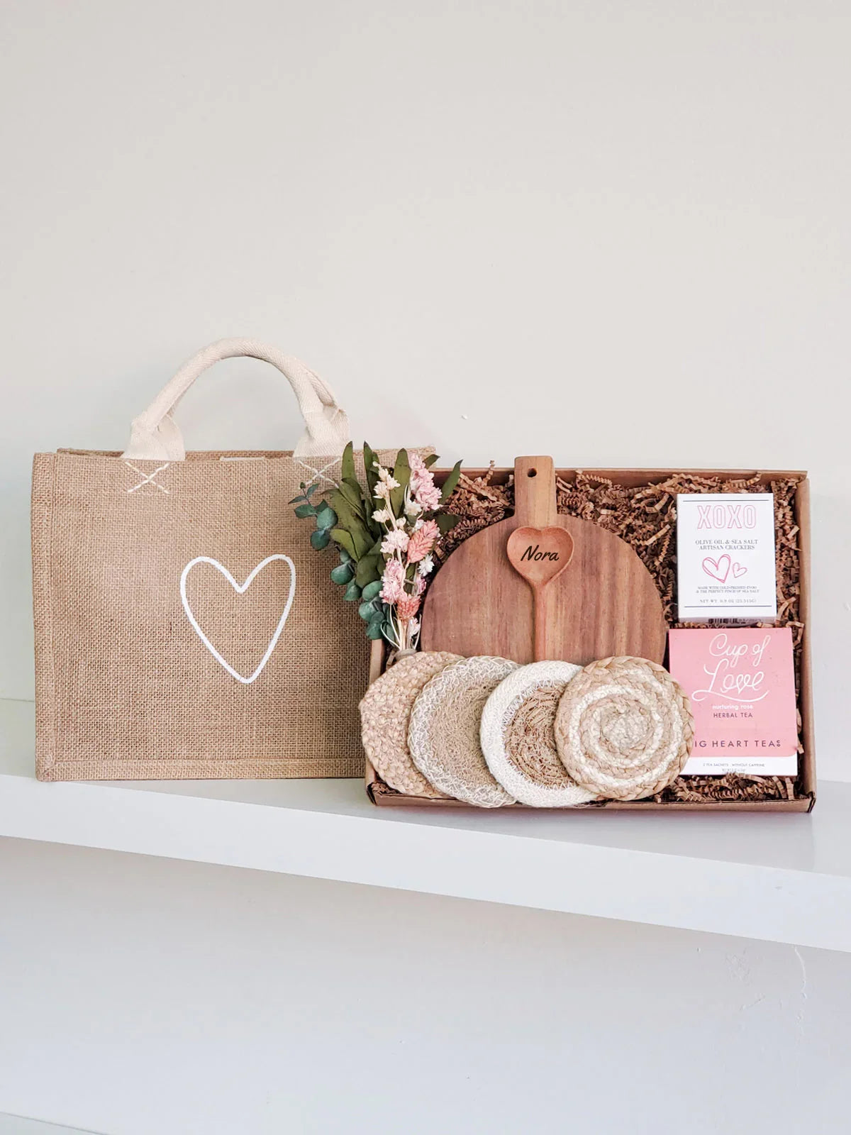Personalized wooden cutting board gift set with coasters, herbal tea, crackers, dried flowers, and burlap tote bag