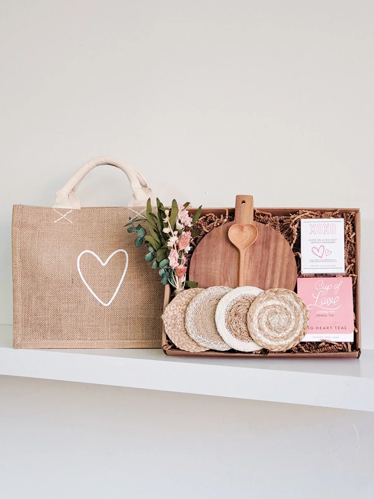 Natural gift box with wooden board, coasters, heart-shaped spoon, herbal tea, and jute bag with white heart