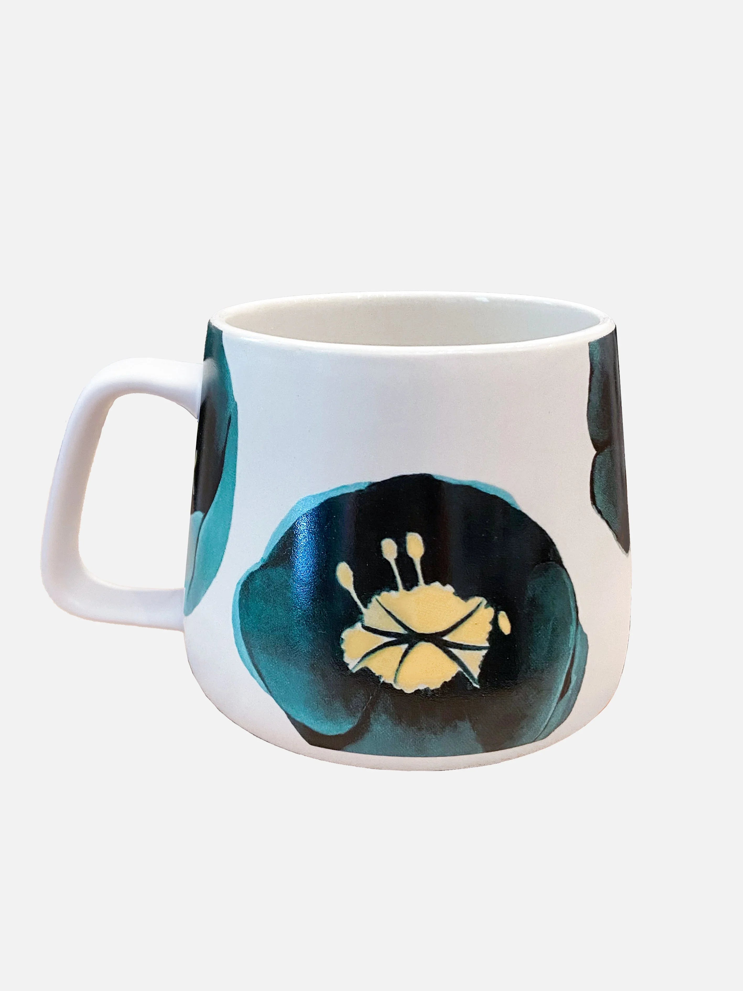 White ceramic coffee mug with large teal and black floral design and yellow center