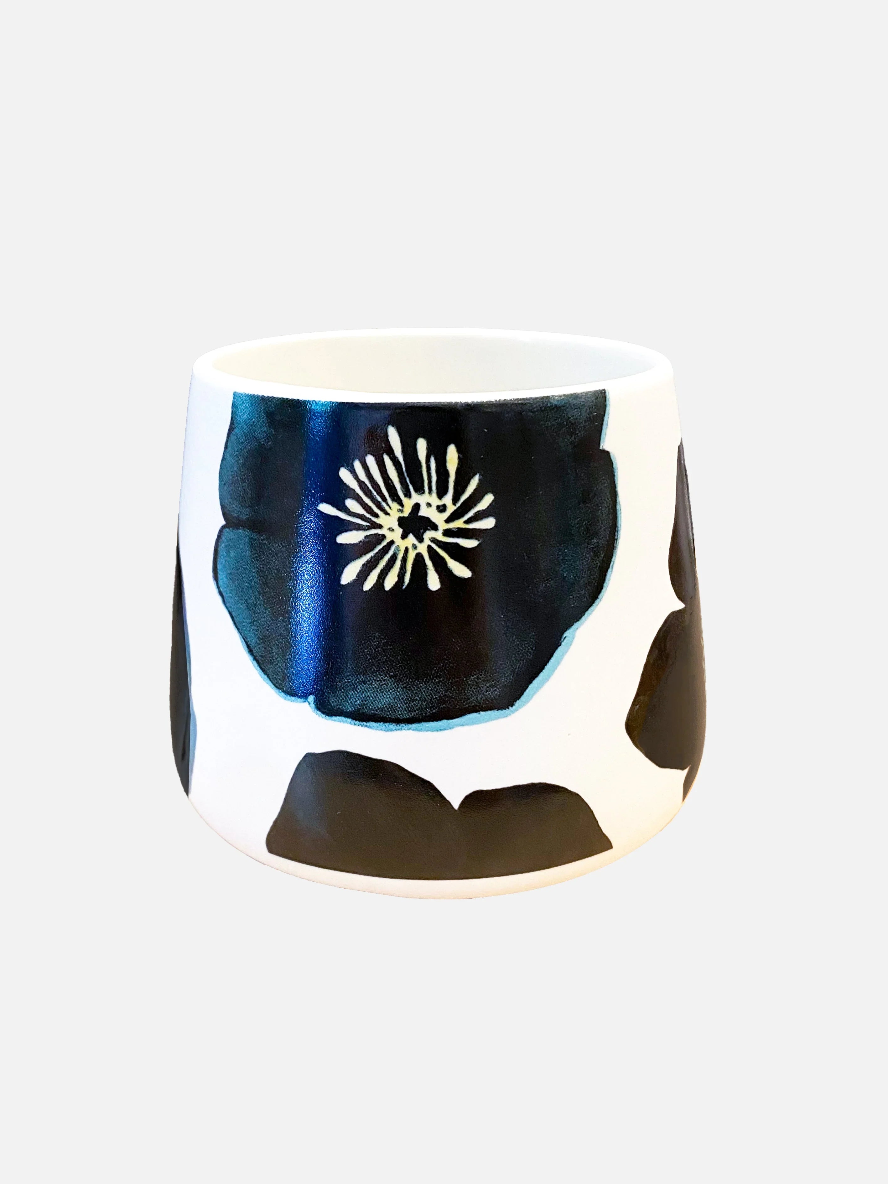 White ceramic mug with large black and blue floral design, studio product shot