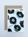 Notecard with green winter rose floral design on light background and brown envelope