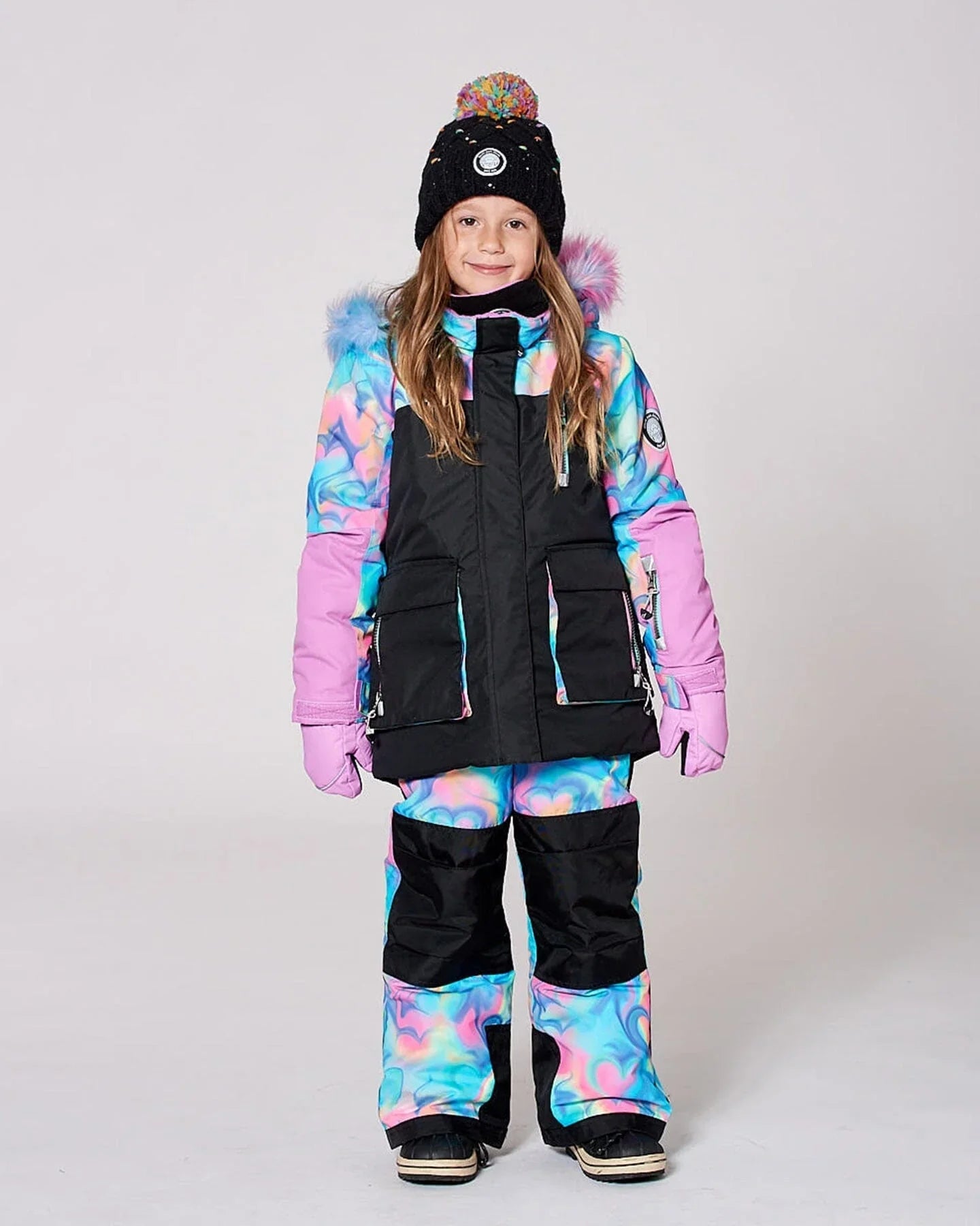 Girl in colorful cosmic winter snowsuit and black knit hat at Qu!rk Boutique