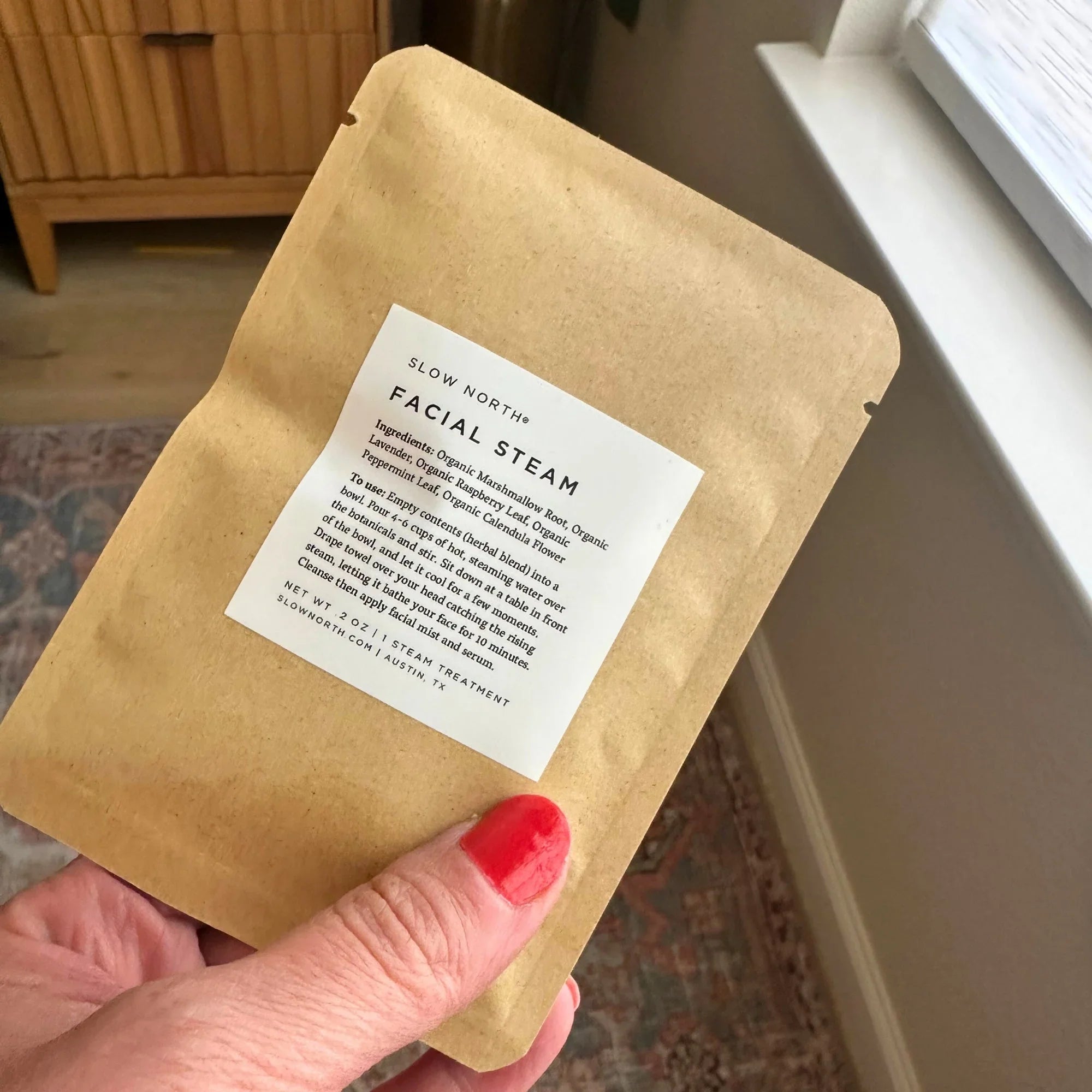 Hand holding Slow North herbal facial steam pouch, natural skincare at Qu!rk Boutique.