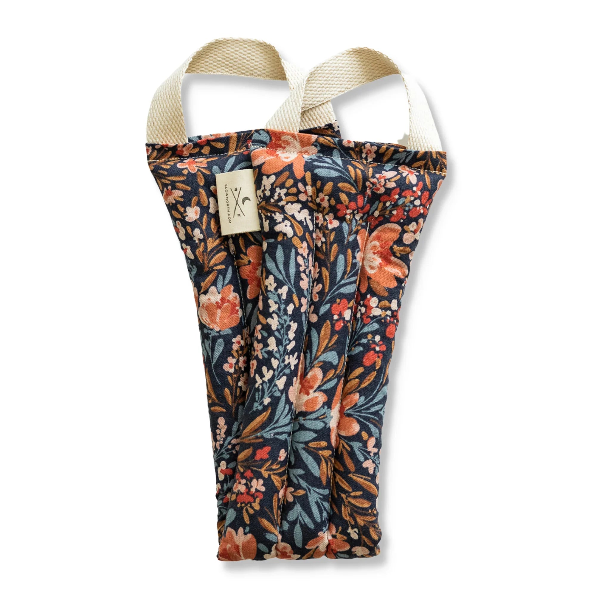 Heated neck wrap with floral fabric and cream handles from Qu!rk Boutique.