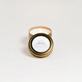 Lit Hello Sunshine hand-poured soy candle with gold tin lid and white label on white background