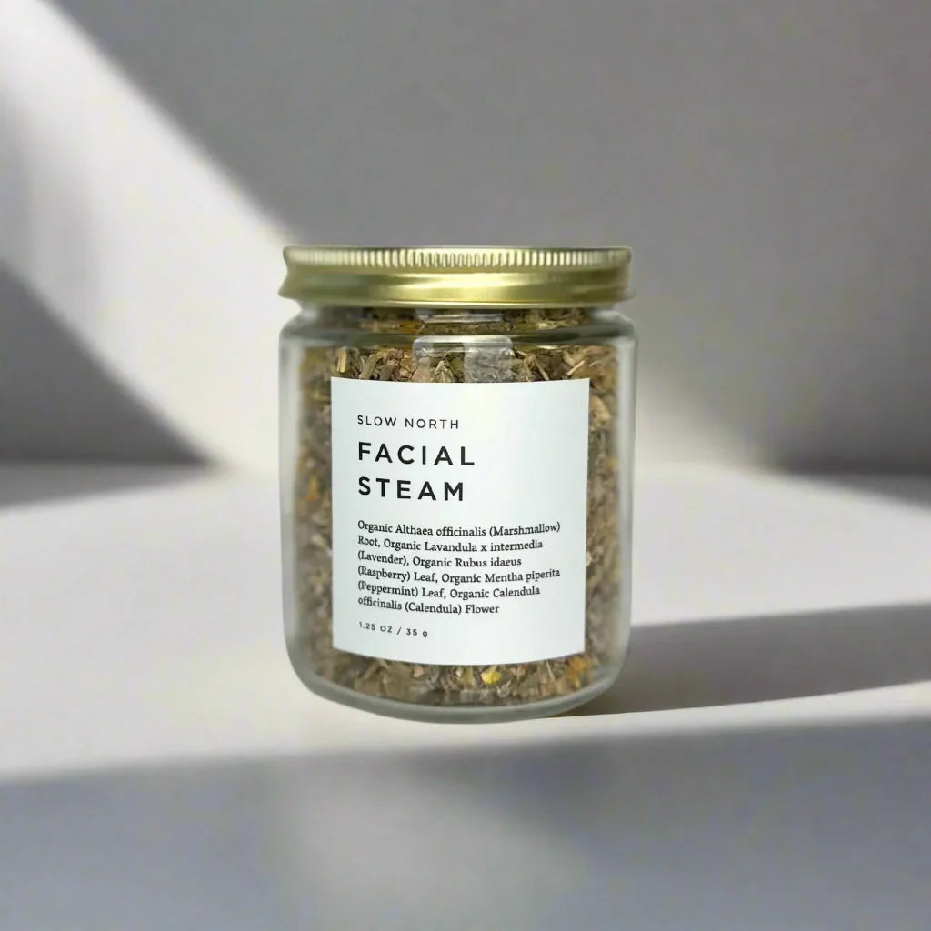 Glass jar of Slow North organic herbal facial steam with gold lid on white background
