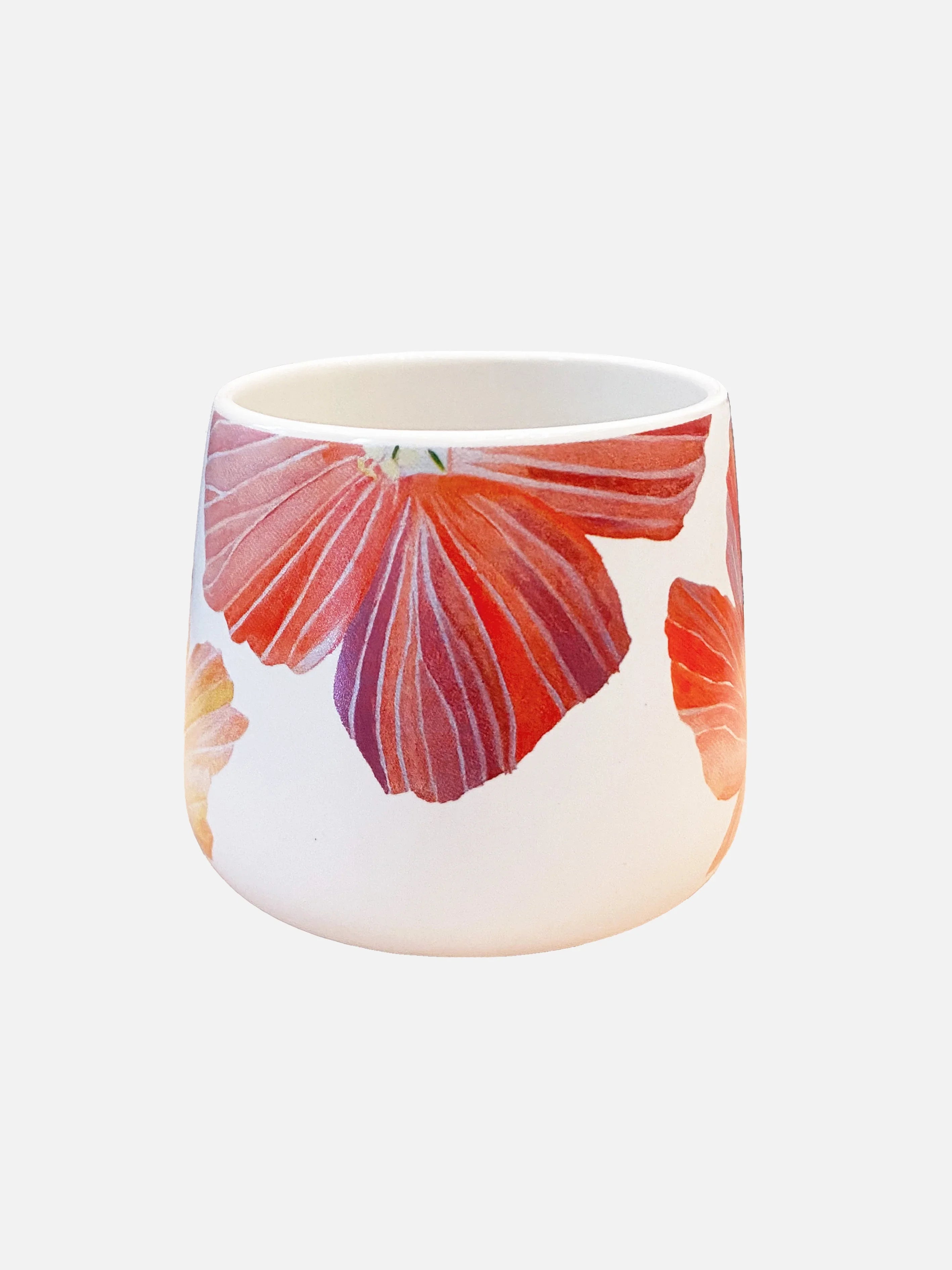 White ceramic mug with large red and orange hibiscus flower design on a plain background