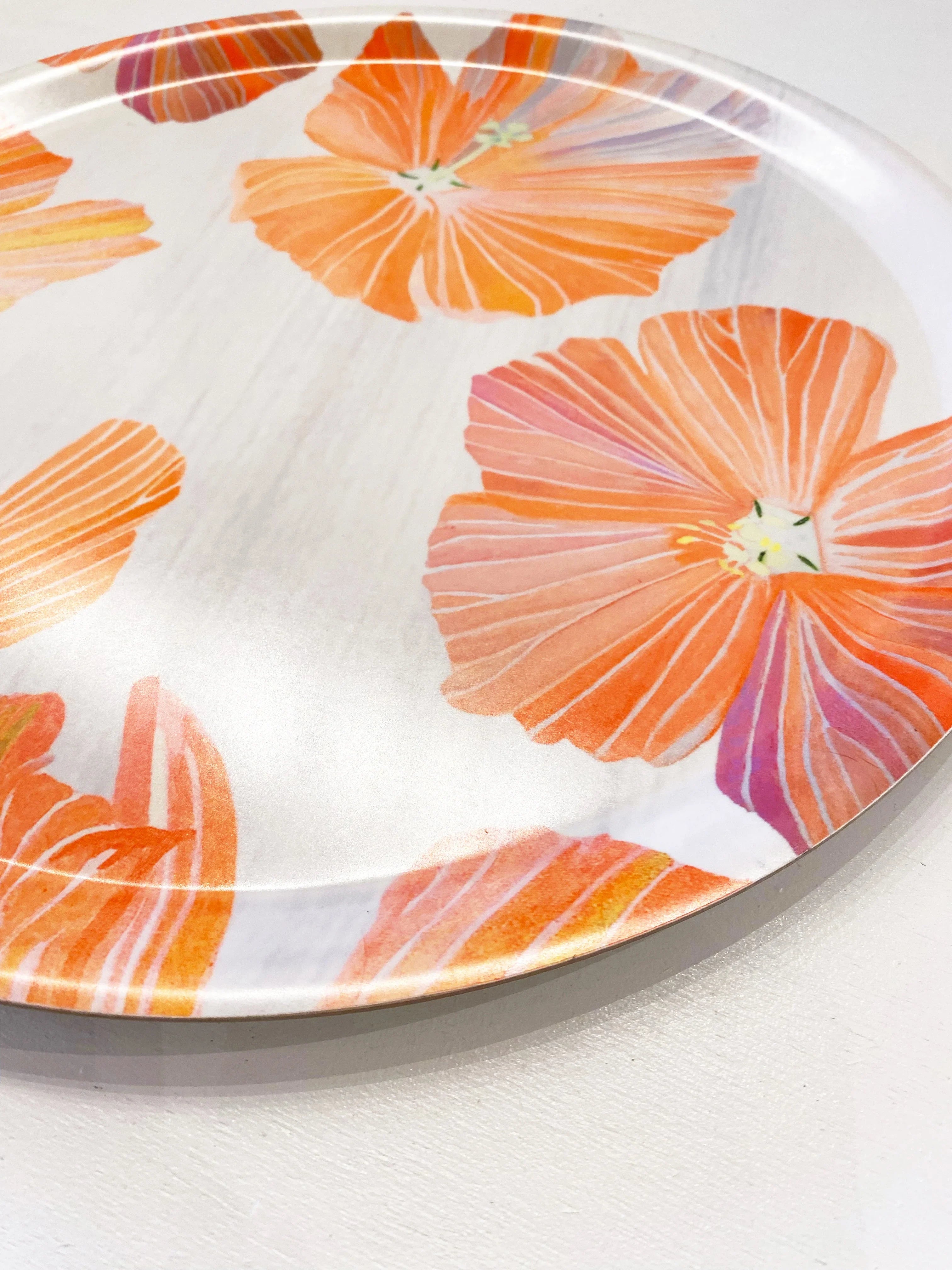 Round tray with orange hibiscus flower design on white background