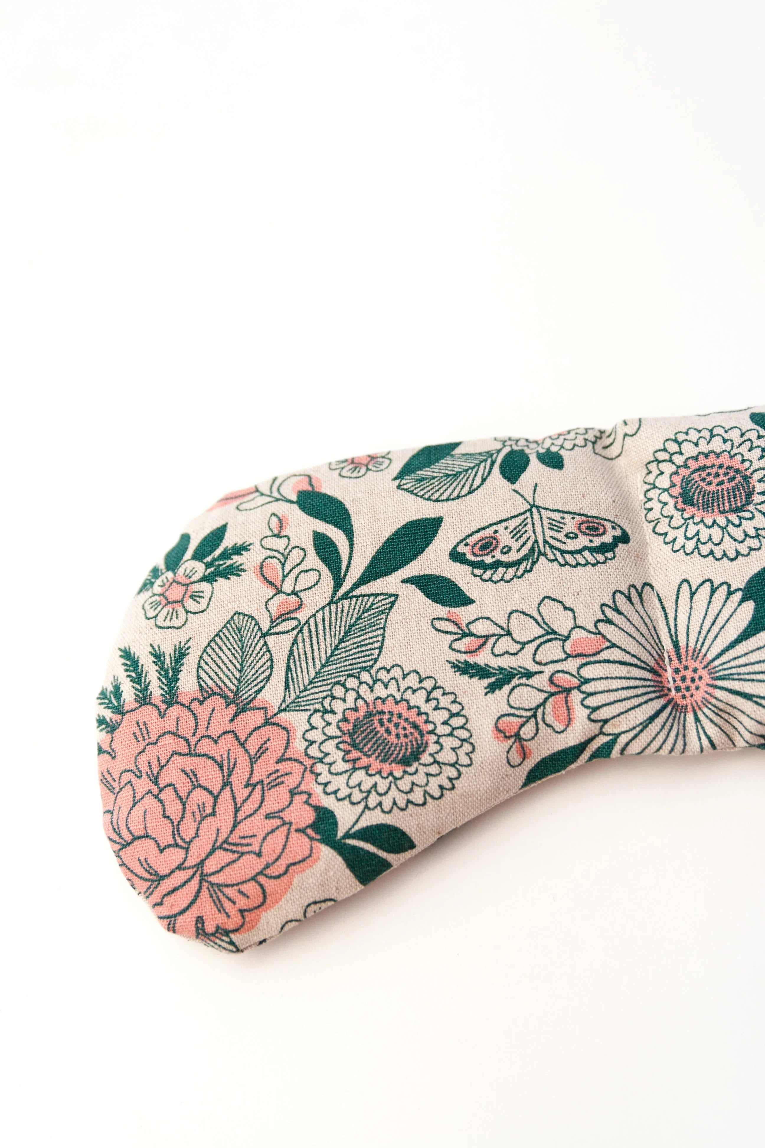 Floral patterned fabric eye pillow with pink and green botanical design on white background