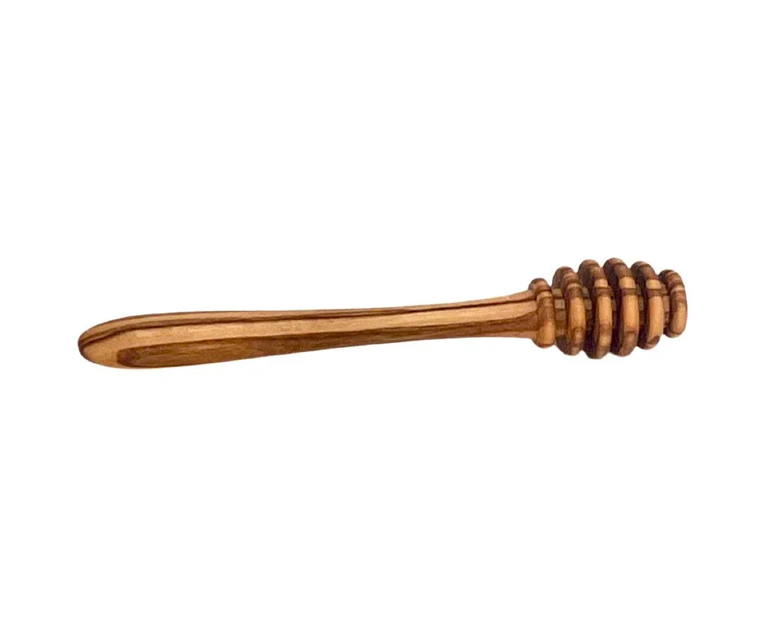 Wooden honey dipper with grooved head against white background