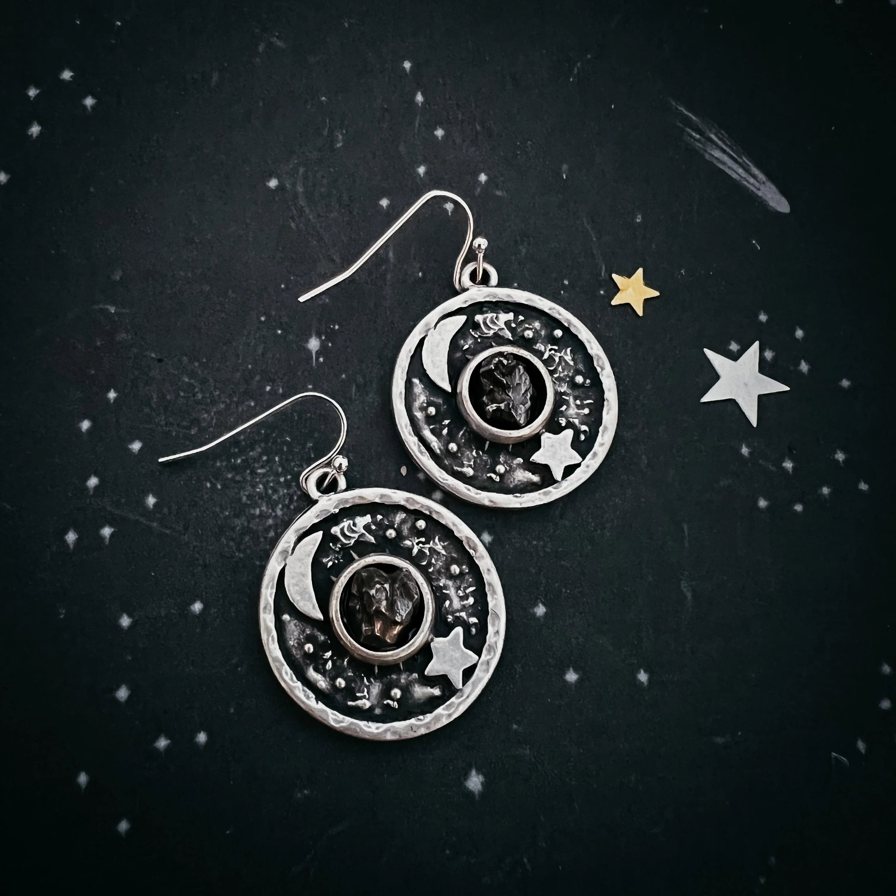 Cosmic-themed silver earrings with moon and star on celestial background, Qu!rk Boutique