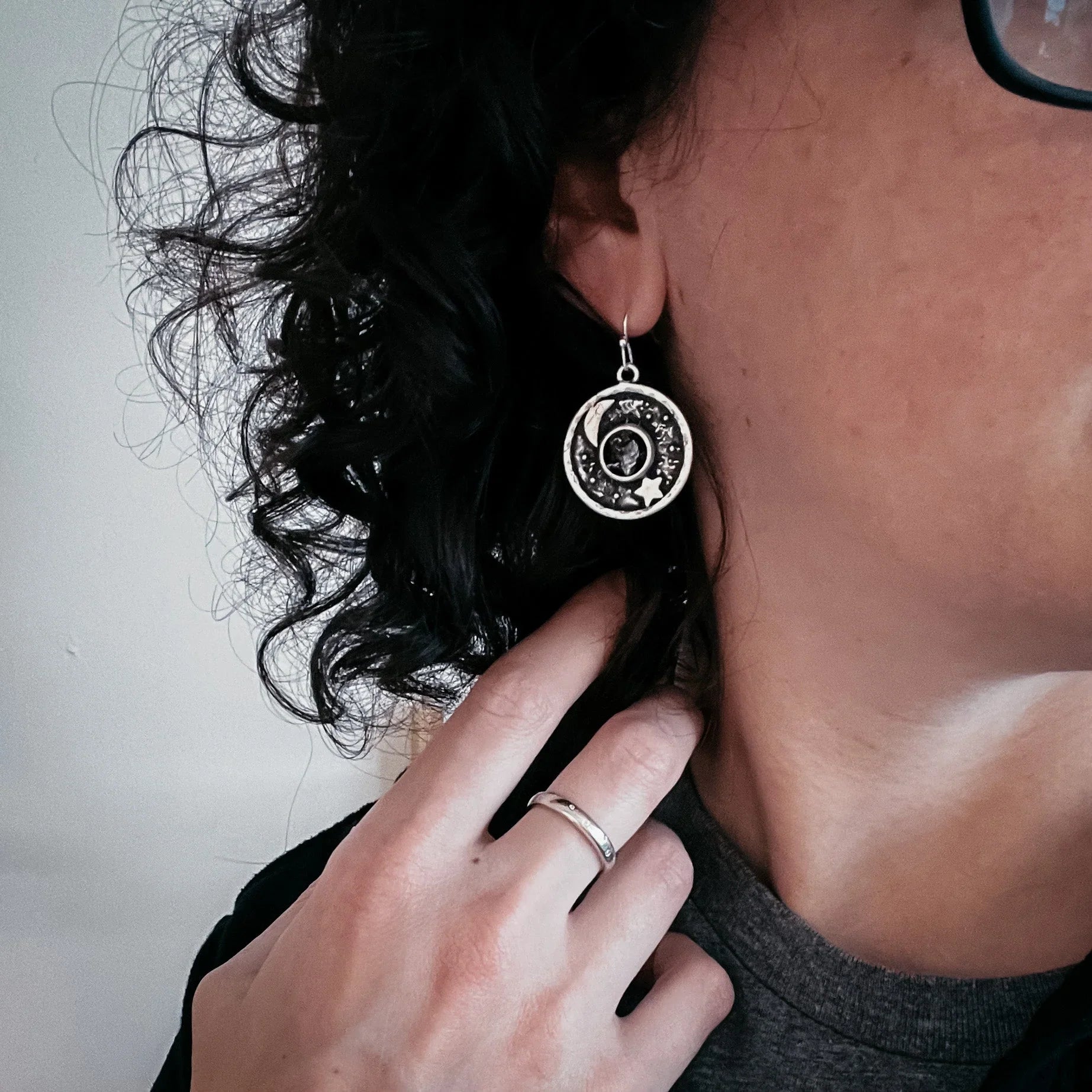 Woman wearing cosmic moon and star earring with silver ring, Qu!rk boutique jewelry