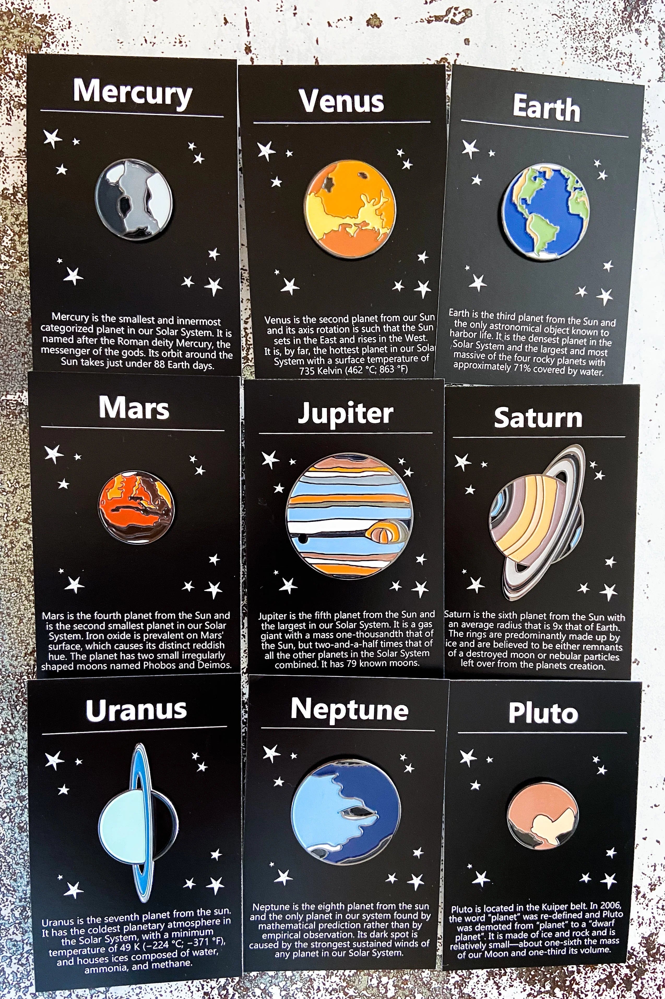 Solar system planet pins displayed on black cards with planetary facts and star illustrations