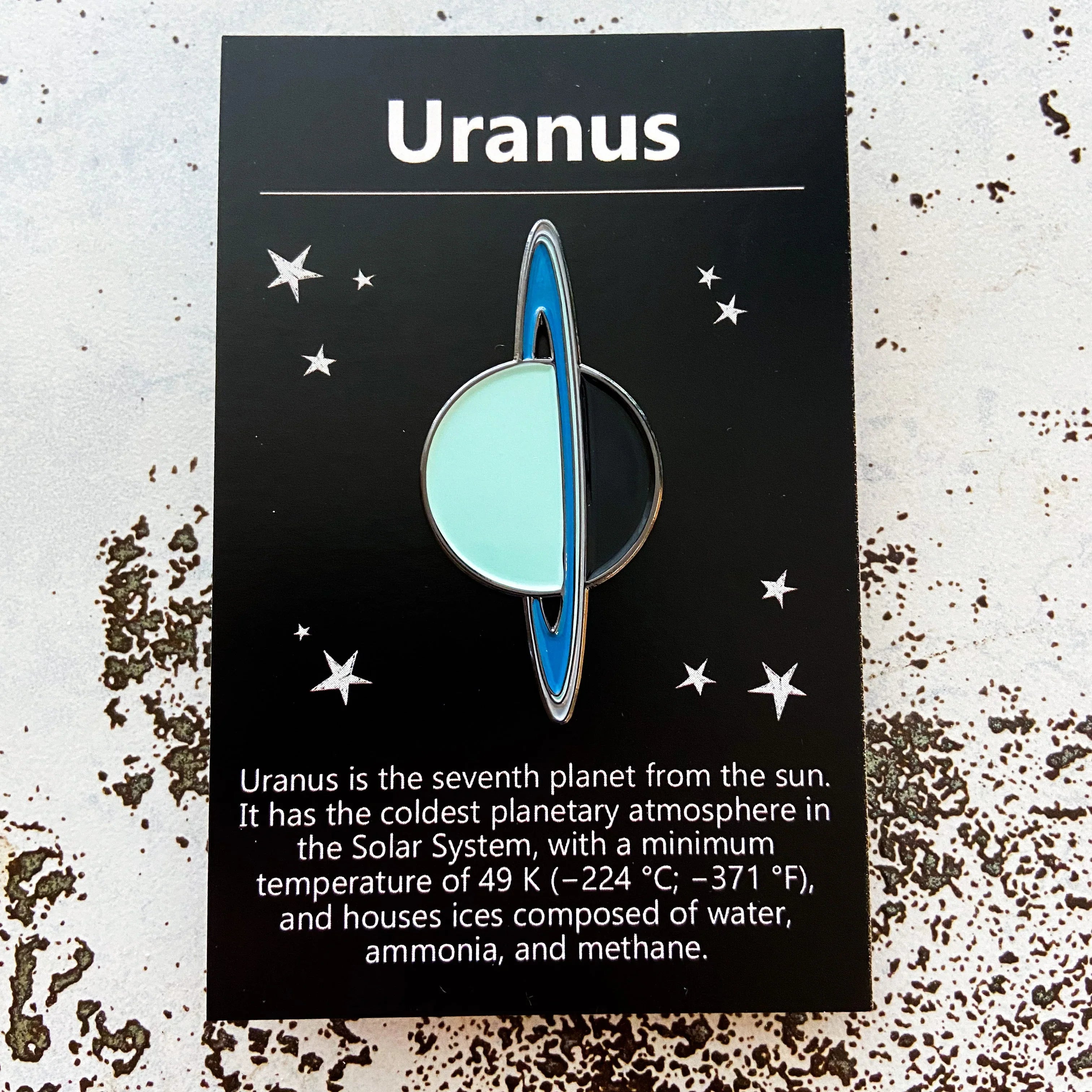 Uranus enamel pin on black card with stars and coldest planet info in the Solar System