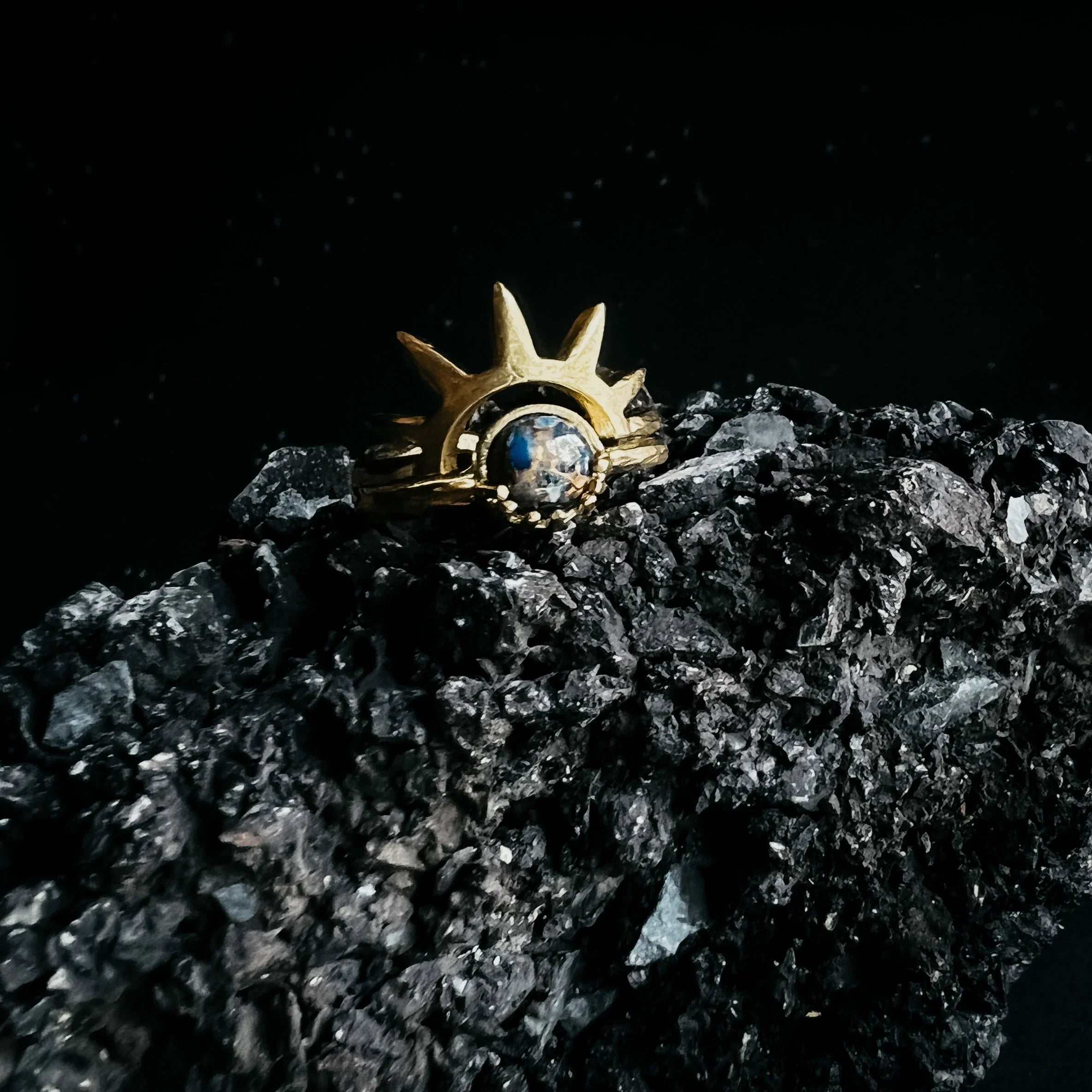 Gold cosmic-inspired artist-designed ring with gemstone on black stone, Qu!rk Boutique jewelry