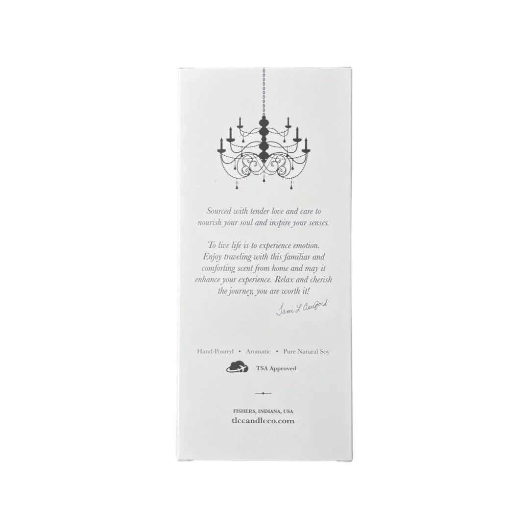 White candle packaging with black chandelier illustration and inspirational text, hand-poured natural soy candle