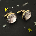 Moon phase cufflinks on black star-patterned fabric with yellow and white star confetti