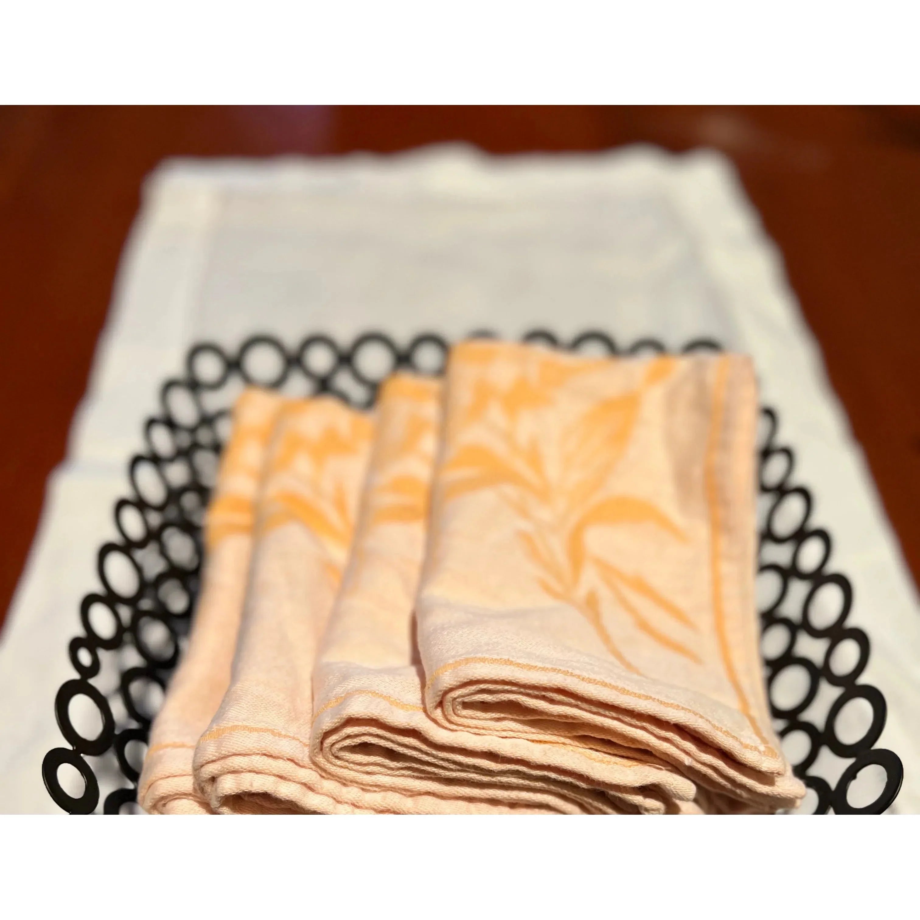 Folded patterned cloth napkins in a black decorative basket on a white cloth, Qu!rk Boutique