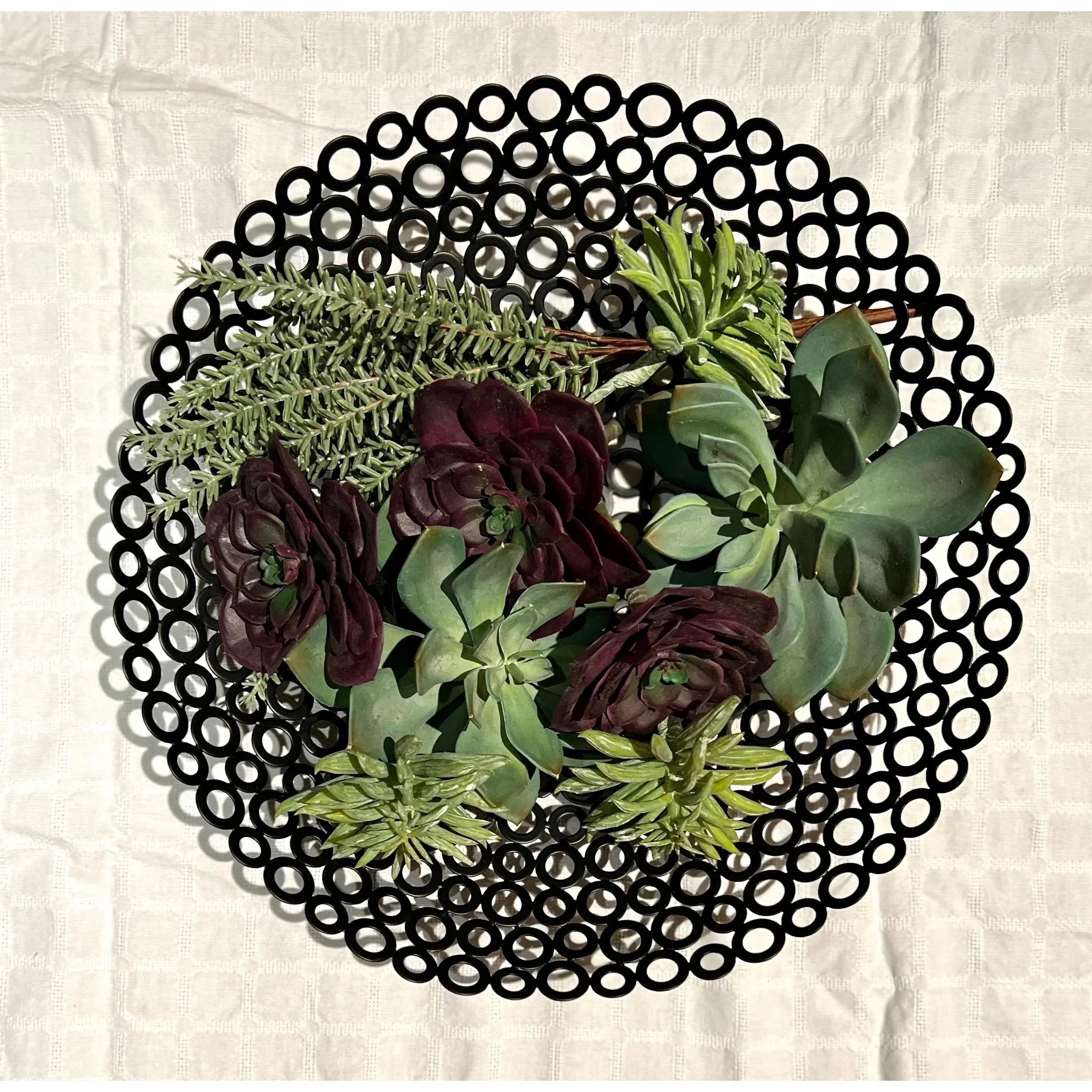 Succulent arrangement on a black circular mat, styled for Qu!rk Boutique gift decor