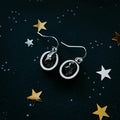 Raw stone silver earrings on a cosmic starry background, Qu!rk Boutique artisan jewelry