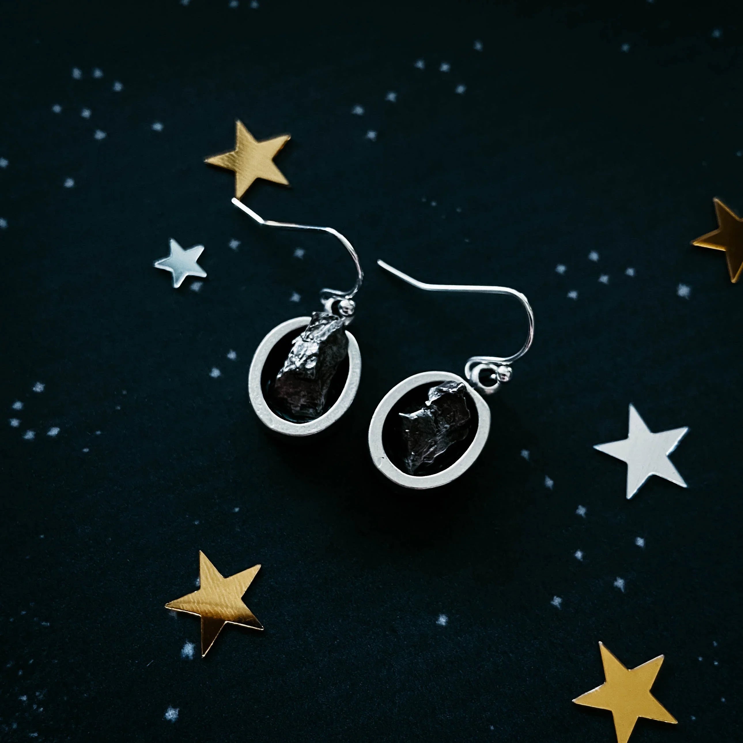 Raw stone silver earrings on a cosmic starry background, Qu!rk Boutique artisan jewelry