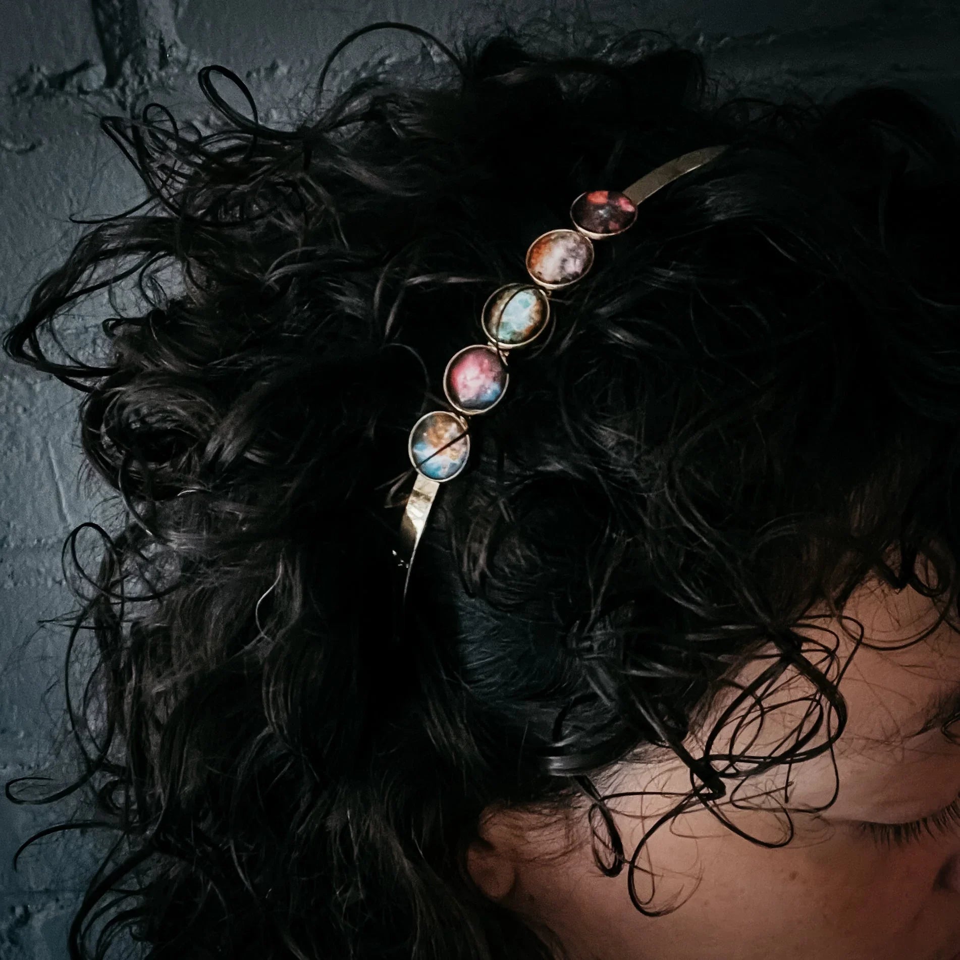 Woman with curly hair wearing a cosmic-themed headband from Qu!rk Boutique