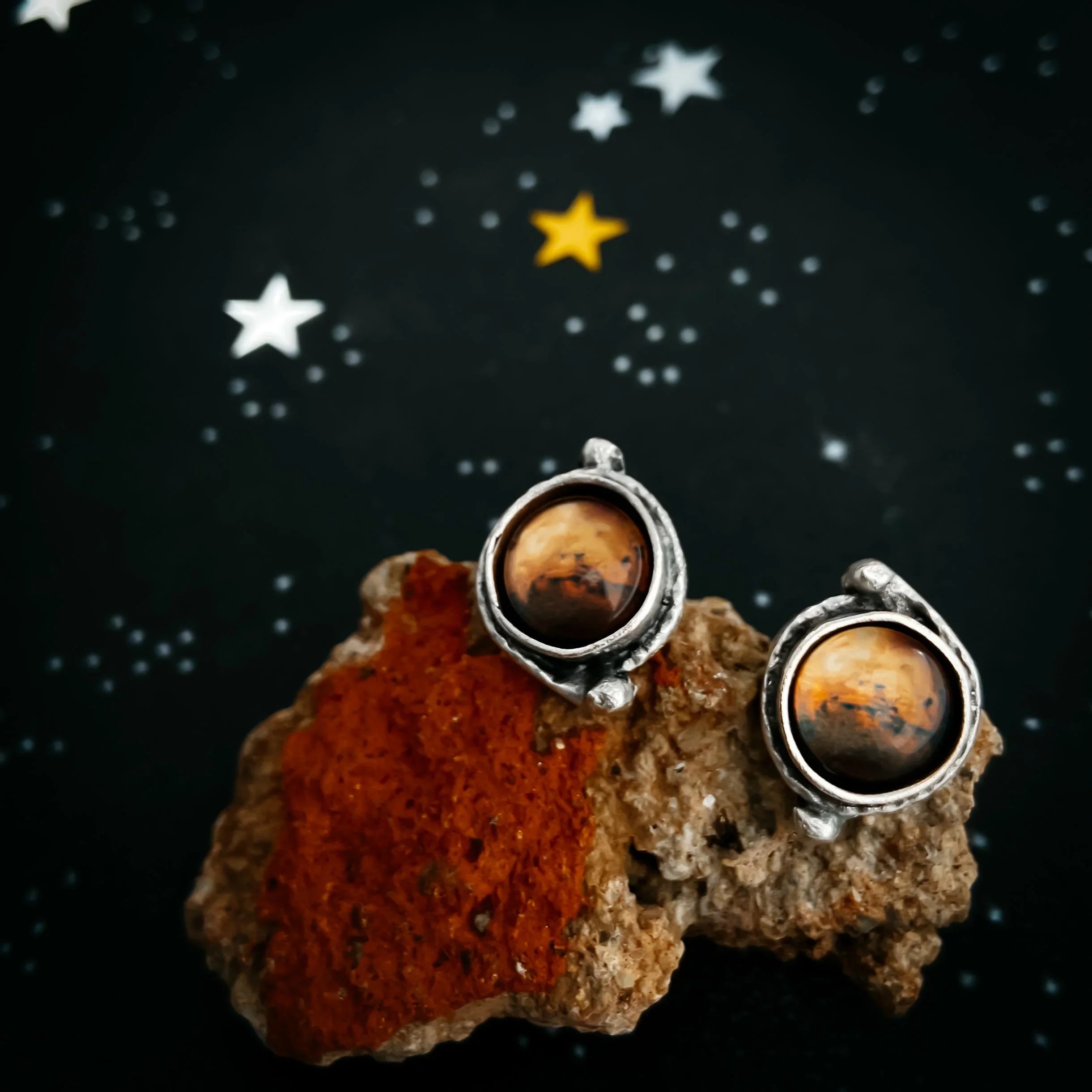 Artist-designed cosmic earrings on stone, starry background, Qu!rk Boutique gift jewelry
