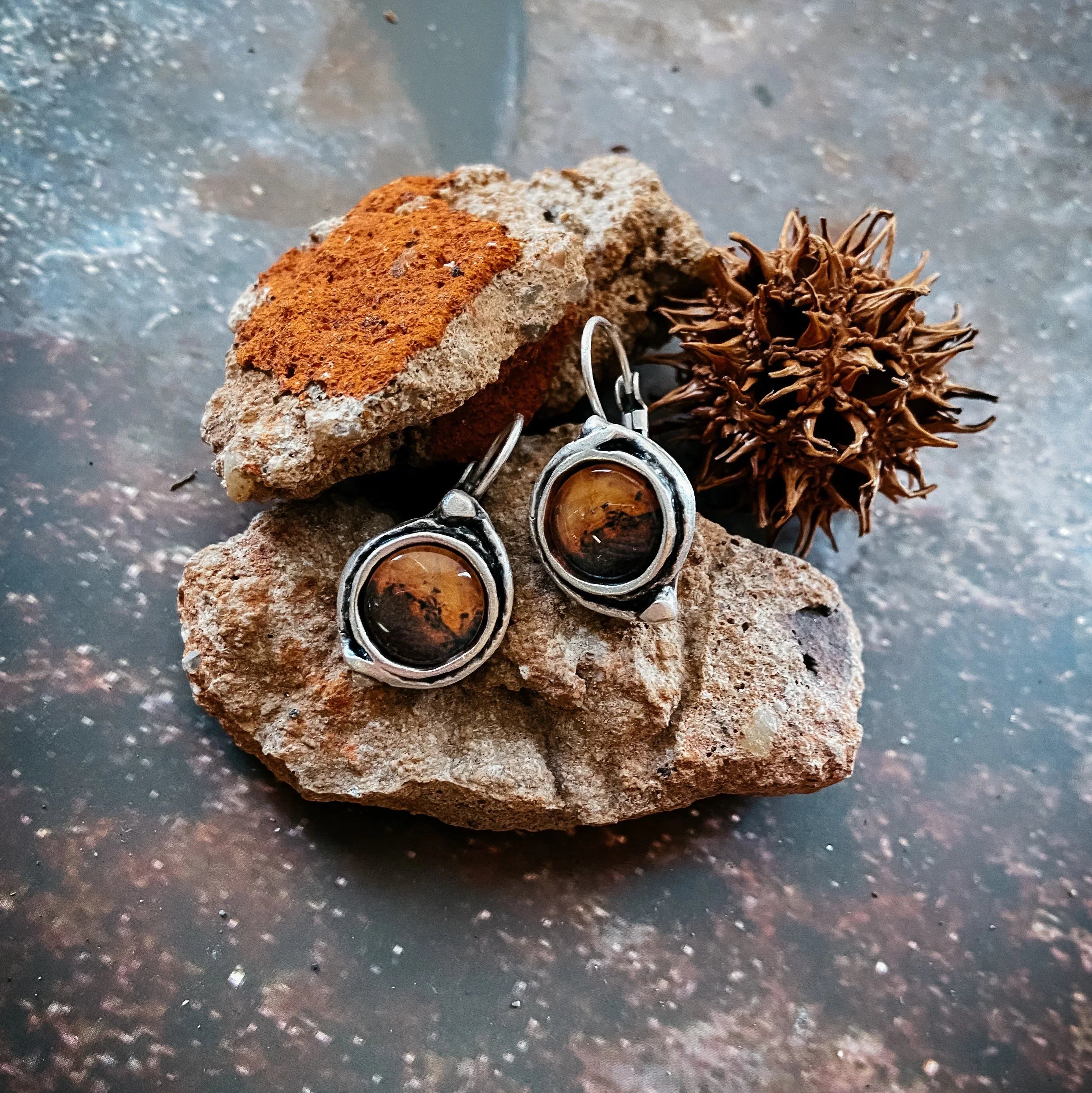 Earthy artisan stone and silver earrings on rustic rock, Qu!rk Boutique cosmic jewelry