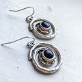 Handcrafted silver spiral earrings with dark blue stone, artisan jewelry at Qu!rk Boutique