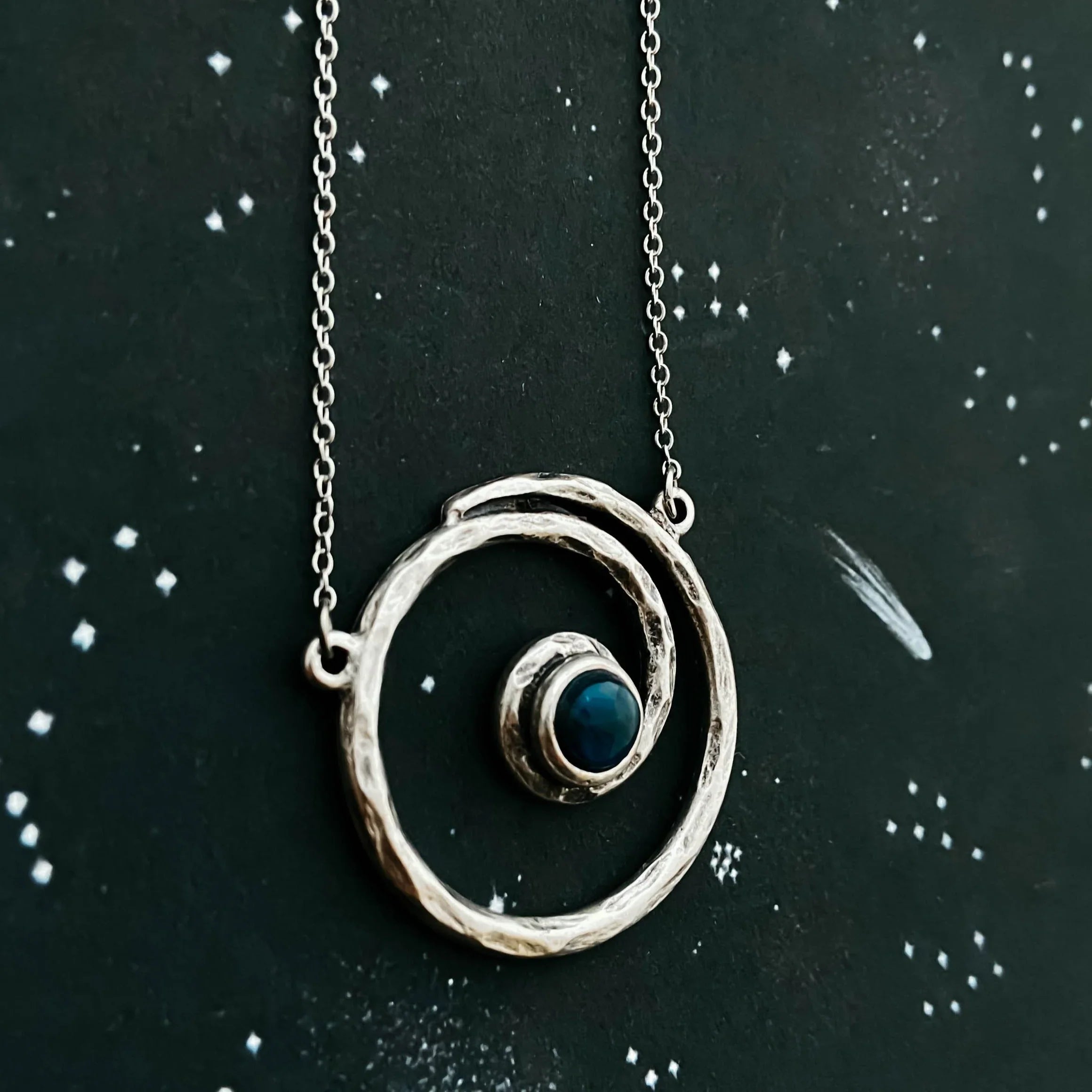 Cosmic-inspired silver spiral necklace with blue stone, Qu!rk Boutique artist-designed jewelry