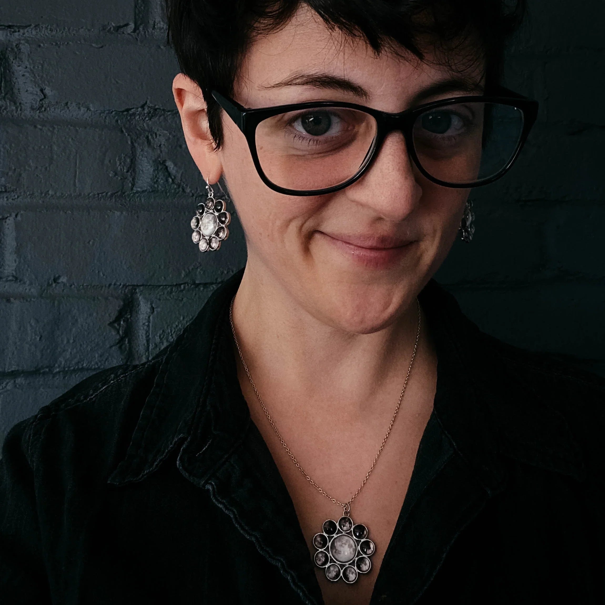 Woman wearing artistic matching silver statement earrings and pendant, Qu!rk Boutique jewelry