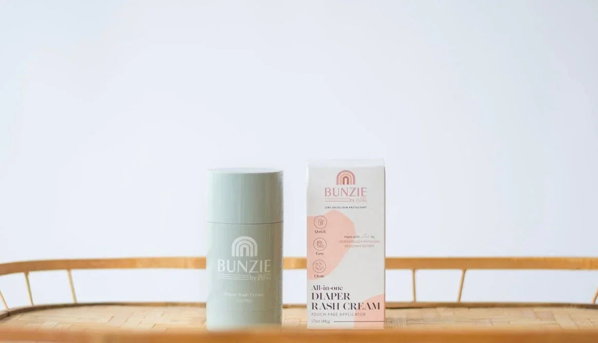 BUNZIE all-in-one diaper rash cream with applicator on wicker tray, eco-friendly skincare product