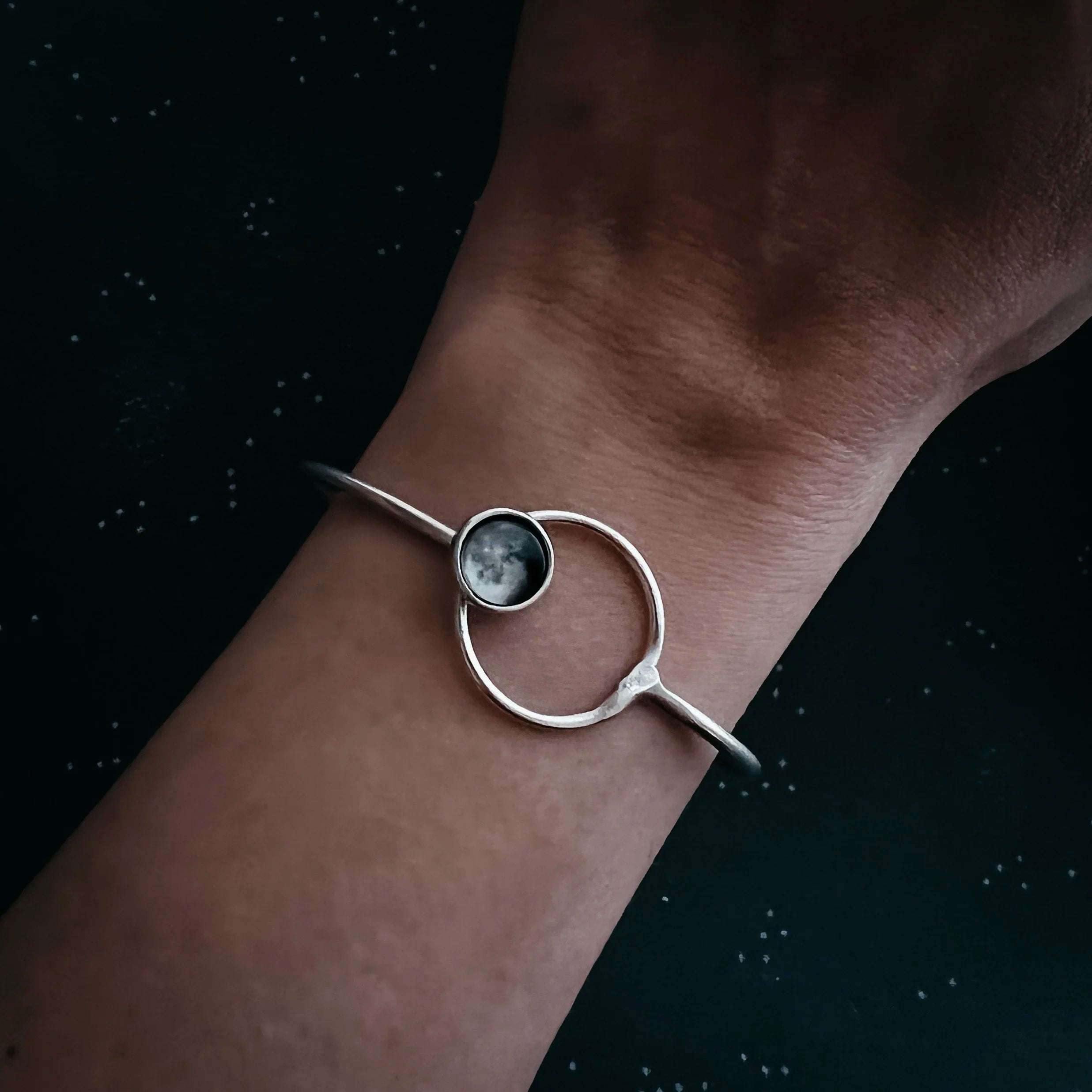Cosmic moon phase silver bracelet on wrist, artist-designed jewelry at Qu!rk Boutique