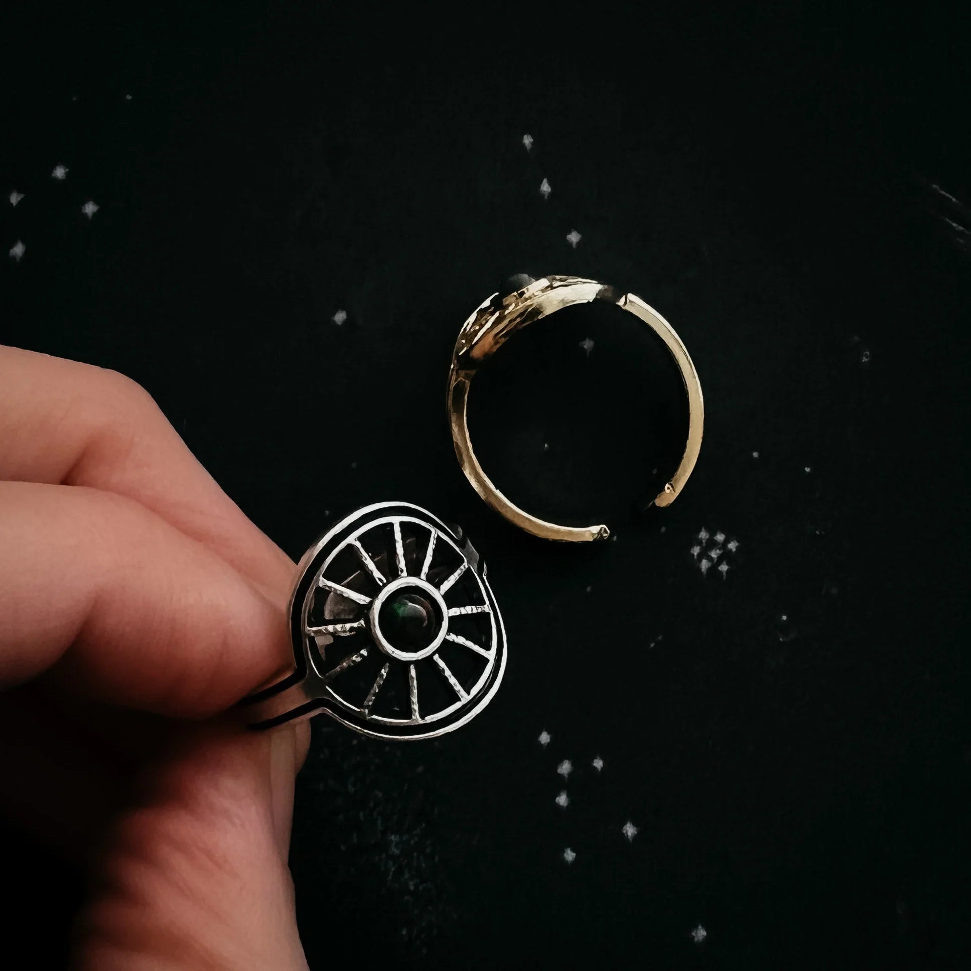 Hand holding artist-designed cosmic ring with black gemstone from Qu!rk Boutique