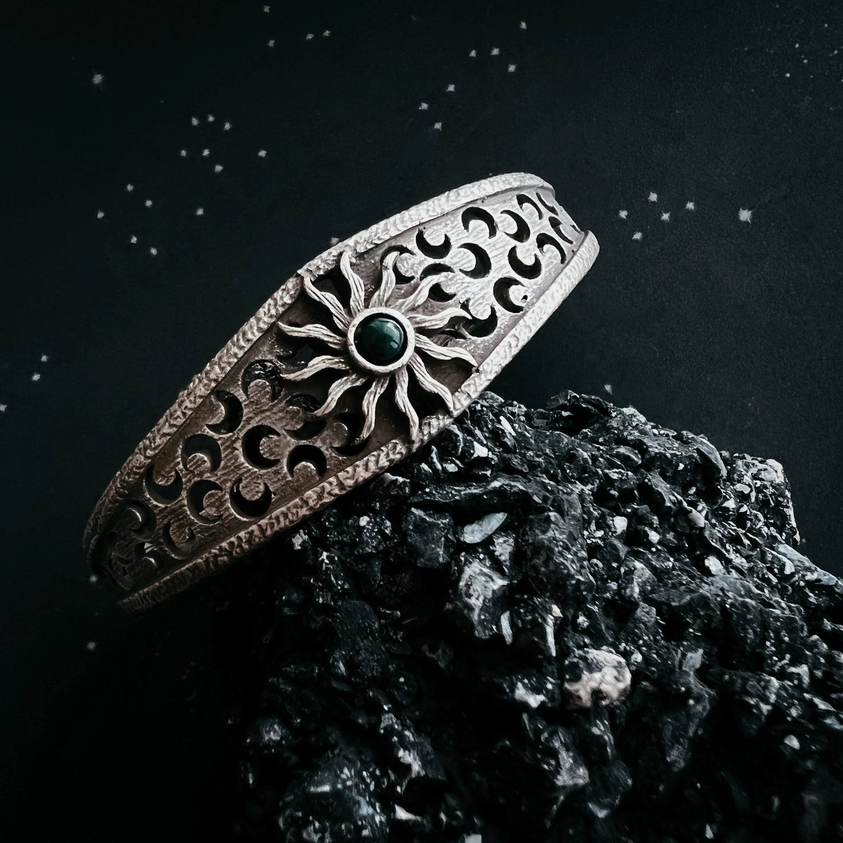 Artist-designed cosmic sun cuff bracelet with gemstone, styled on black rock at Qu!rk Boutique