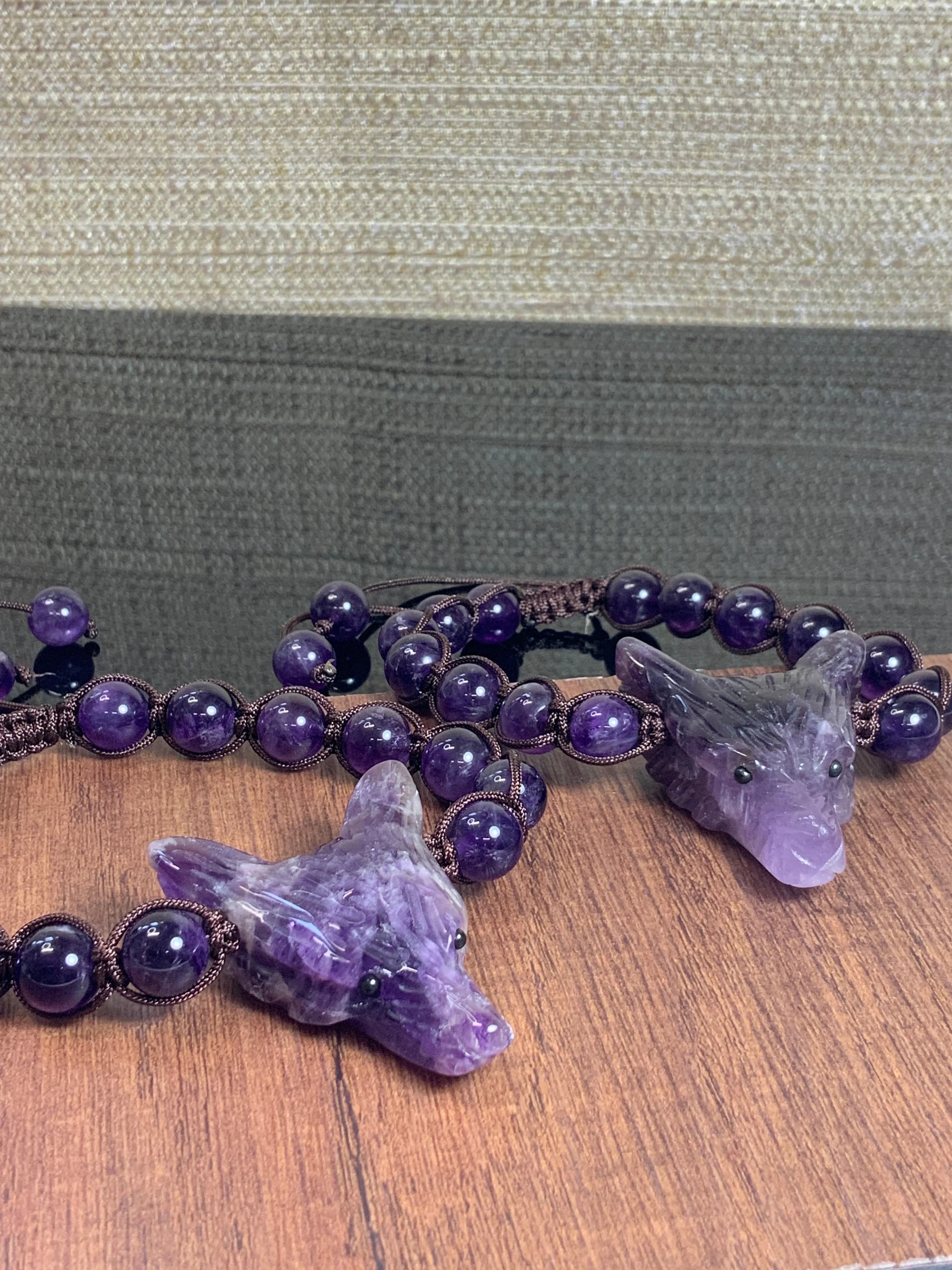 Amethyst wolf head beaded bracelets on a wood surface at Qu!rk Boutique & Gift Shop
