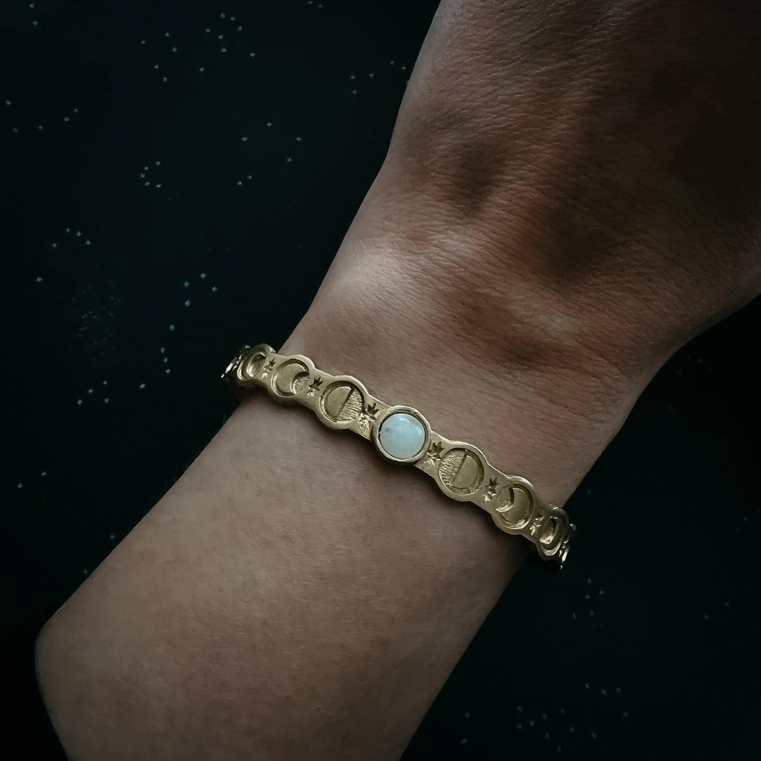 Gold moon phase bracelet with white gemstone on wrist, Qu!rk Boutique cosmic jewelry