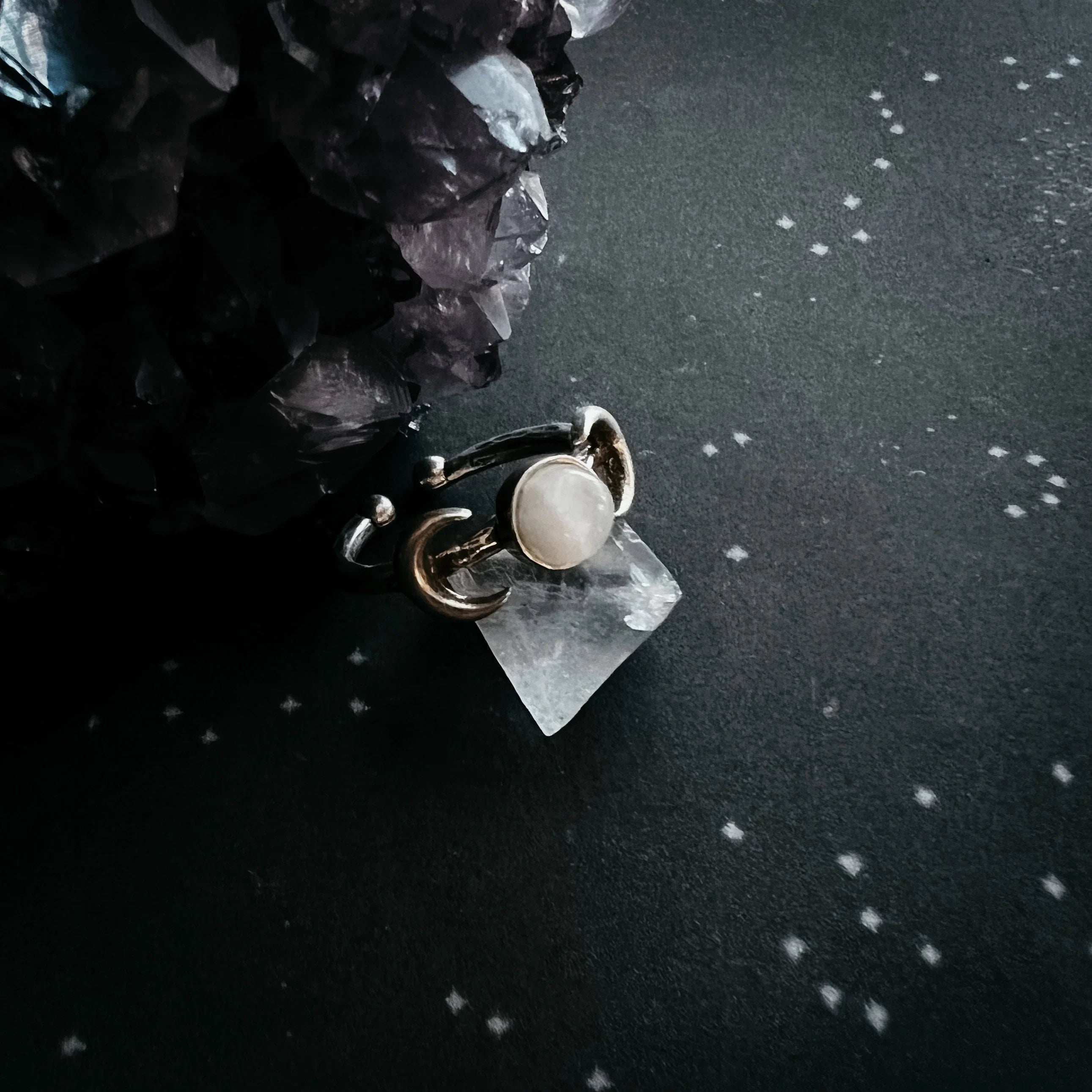 Cosmic crystal ring with moon detail on starry background at Qu!rk Boutique