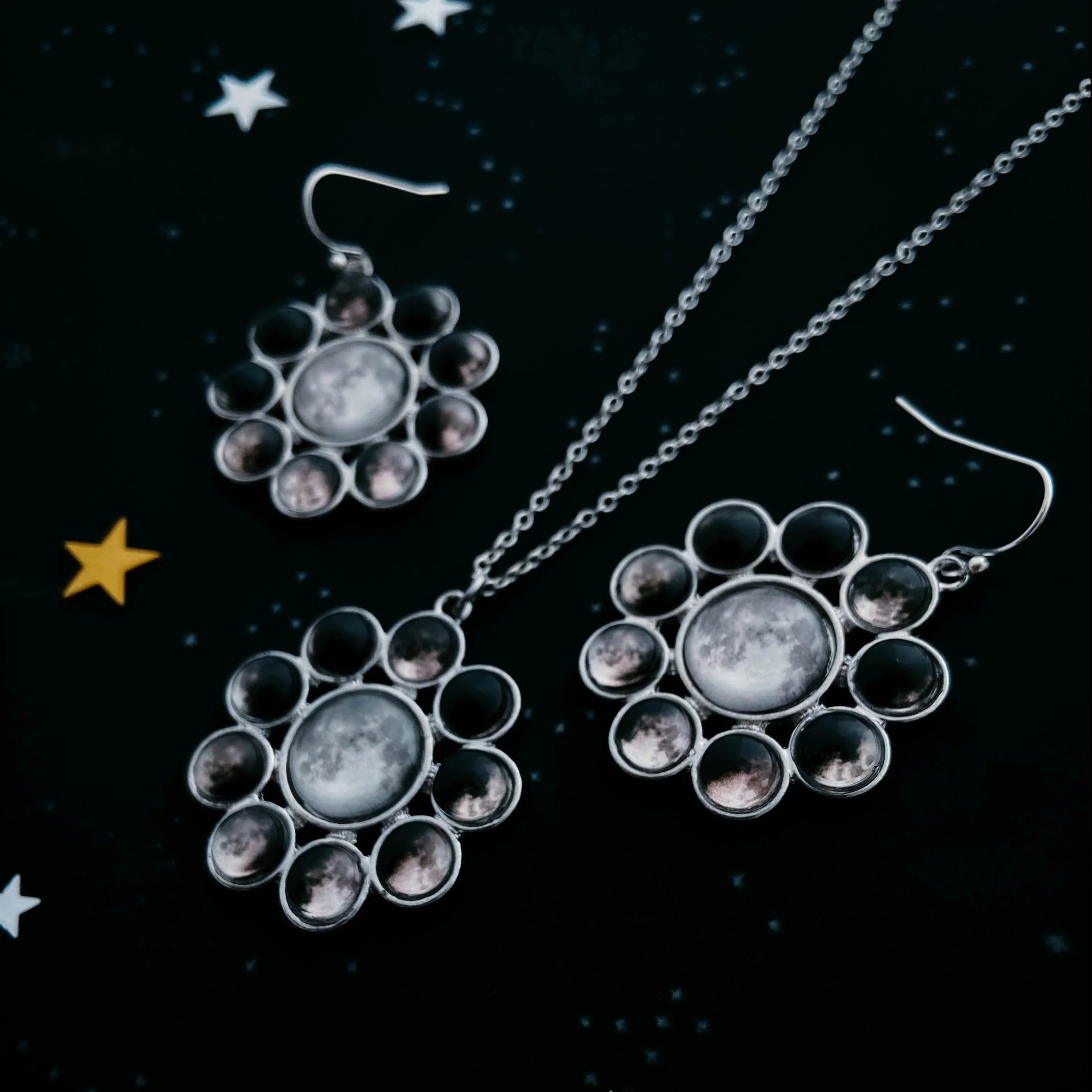 Moon phase earrings and necklace set on starry background at Qu!rk Boutique