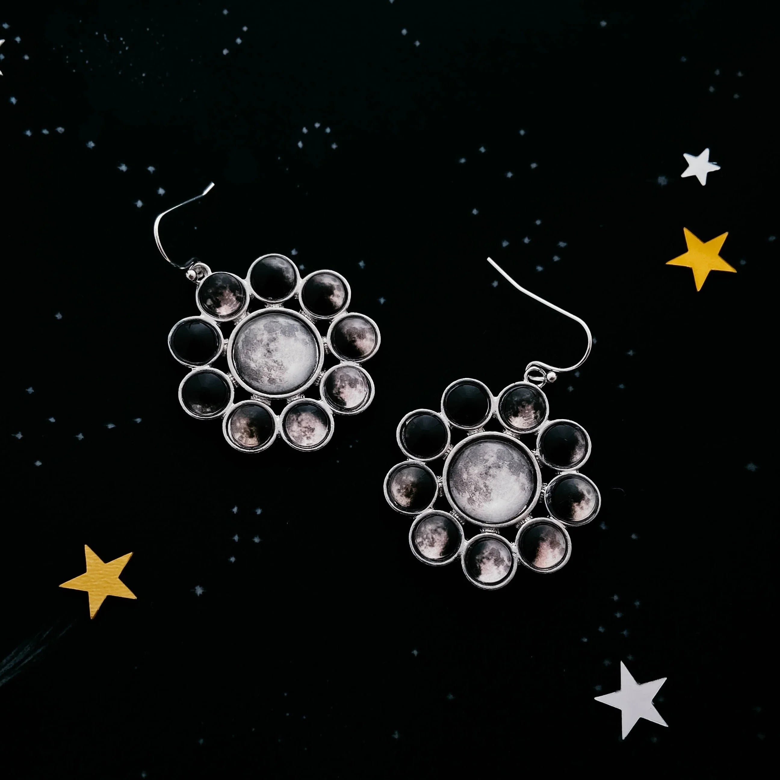 Moon phase dangle earrings on starry black background, Qu!rk Boutique cosmic jewelry