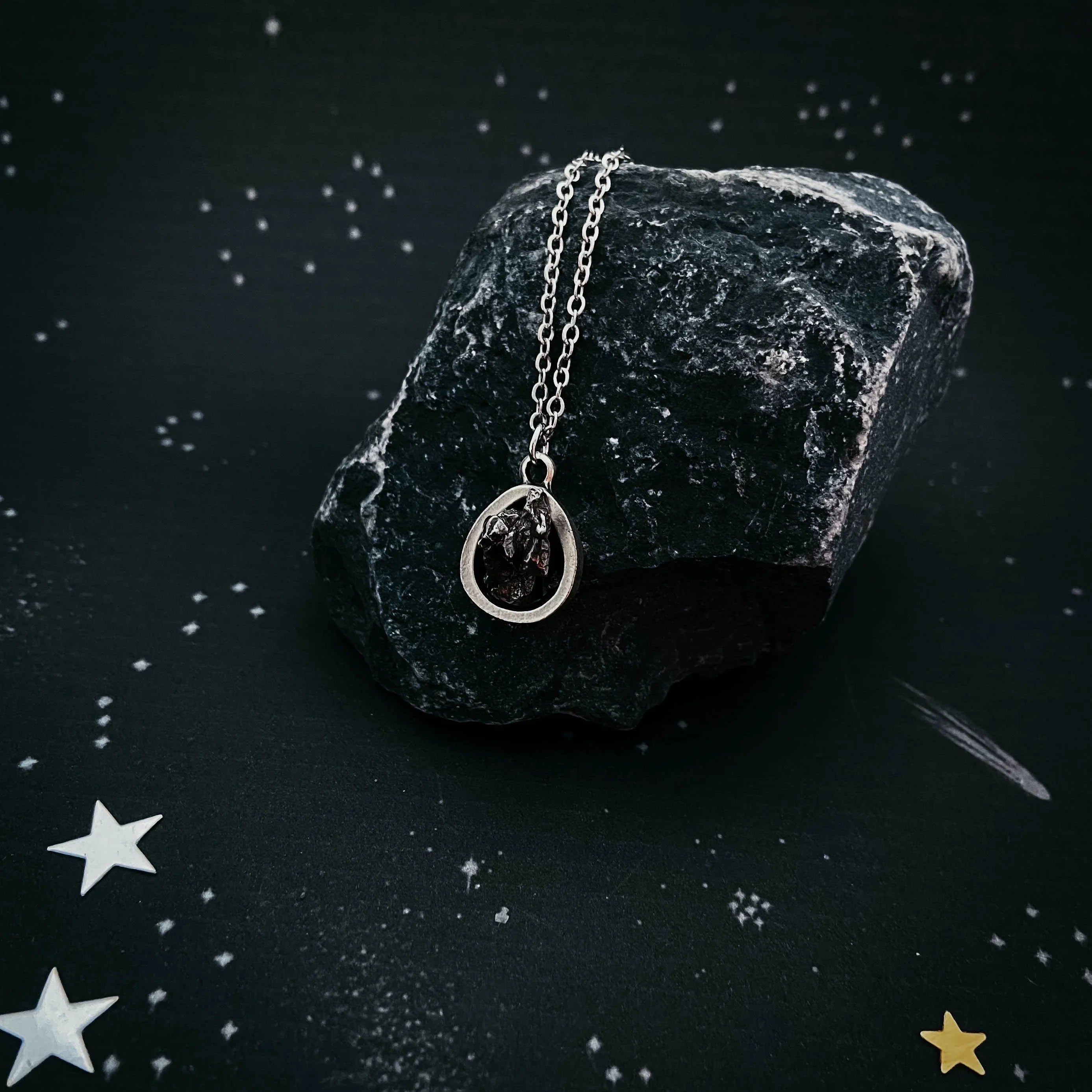 Cosmic-inspired silver pendant necklace on dark stone, Qu!rk Boutique artist-designed jewelry